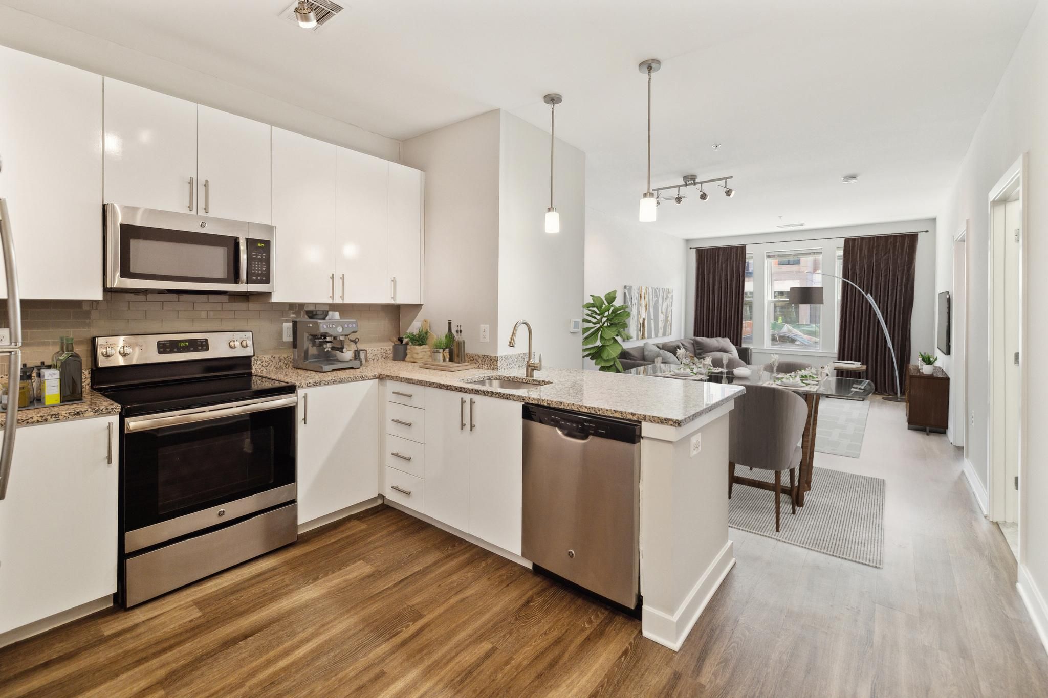 Modern kitchen with stainless steel appliances and an open layout to a dining area.