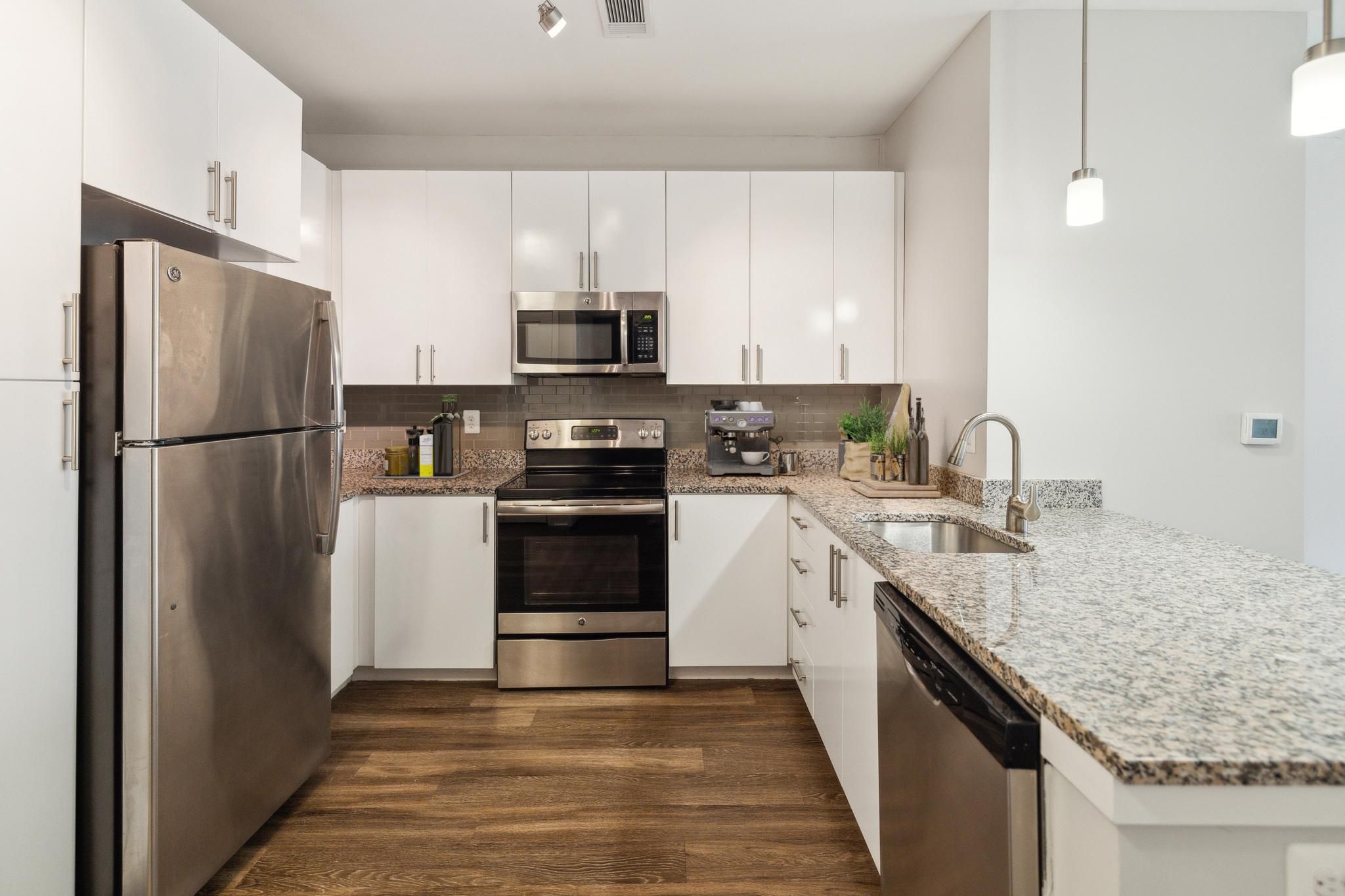 Modern kitchen with stainless steel appliances and granite countertops.