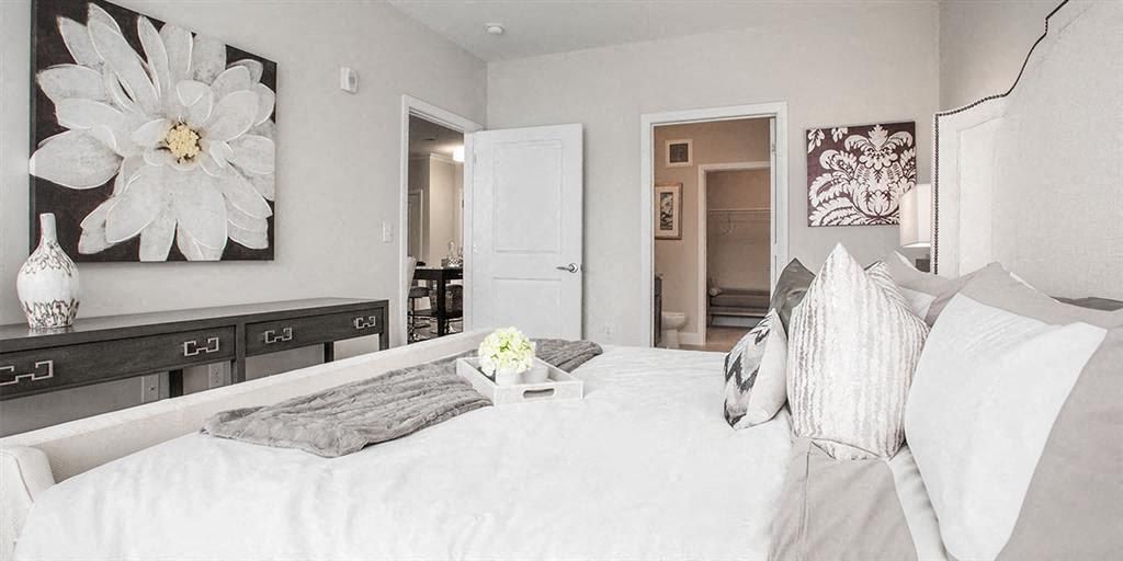 Bright bedroom with floral art, a cozy bed, and neutral decor.