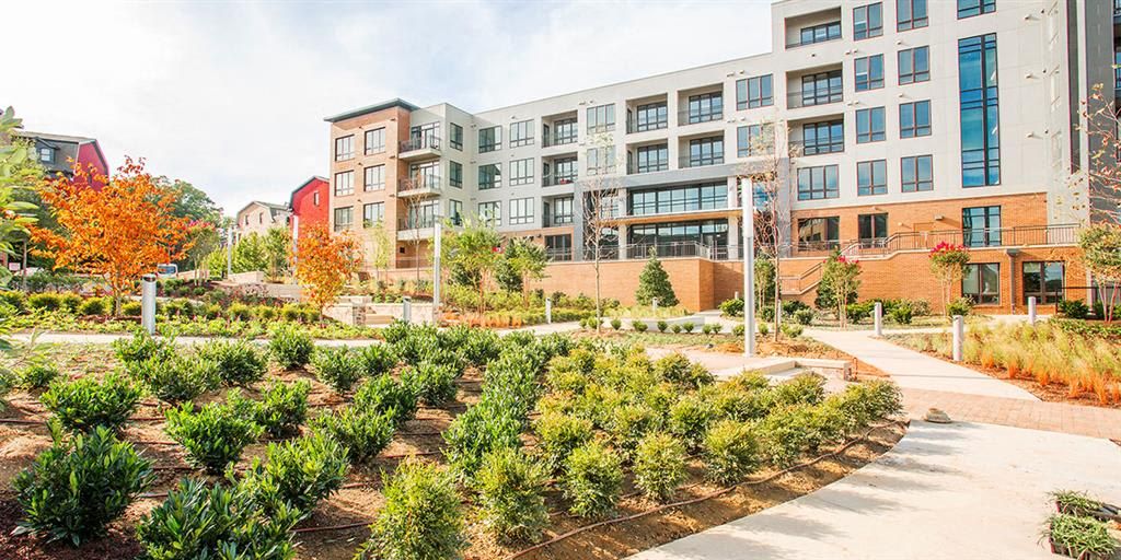 Modern building with landscaped gardens and colorful trees.