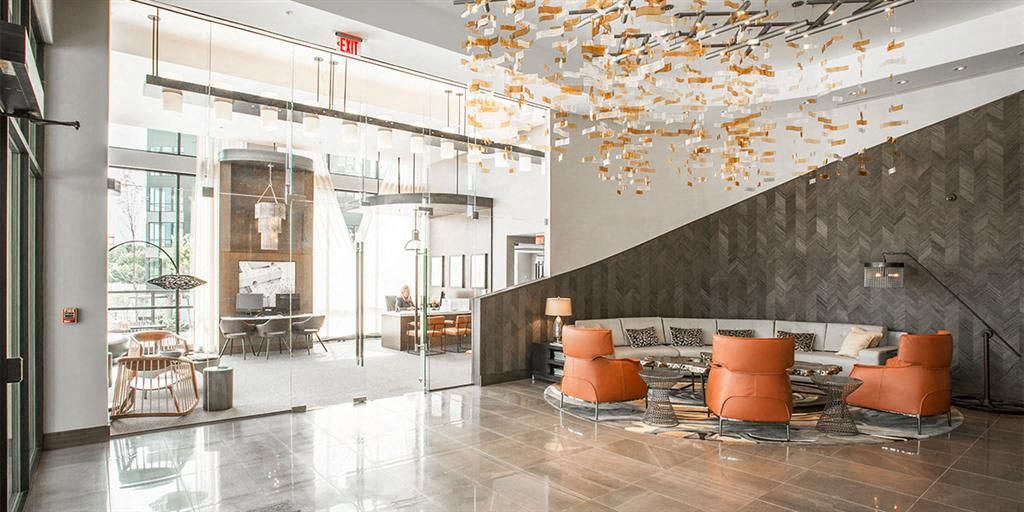 Modern lobby with a textured wall, stylish seating, and decorative ceiling elements.