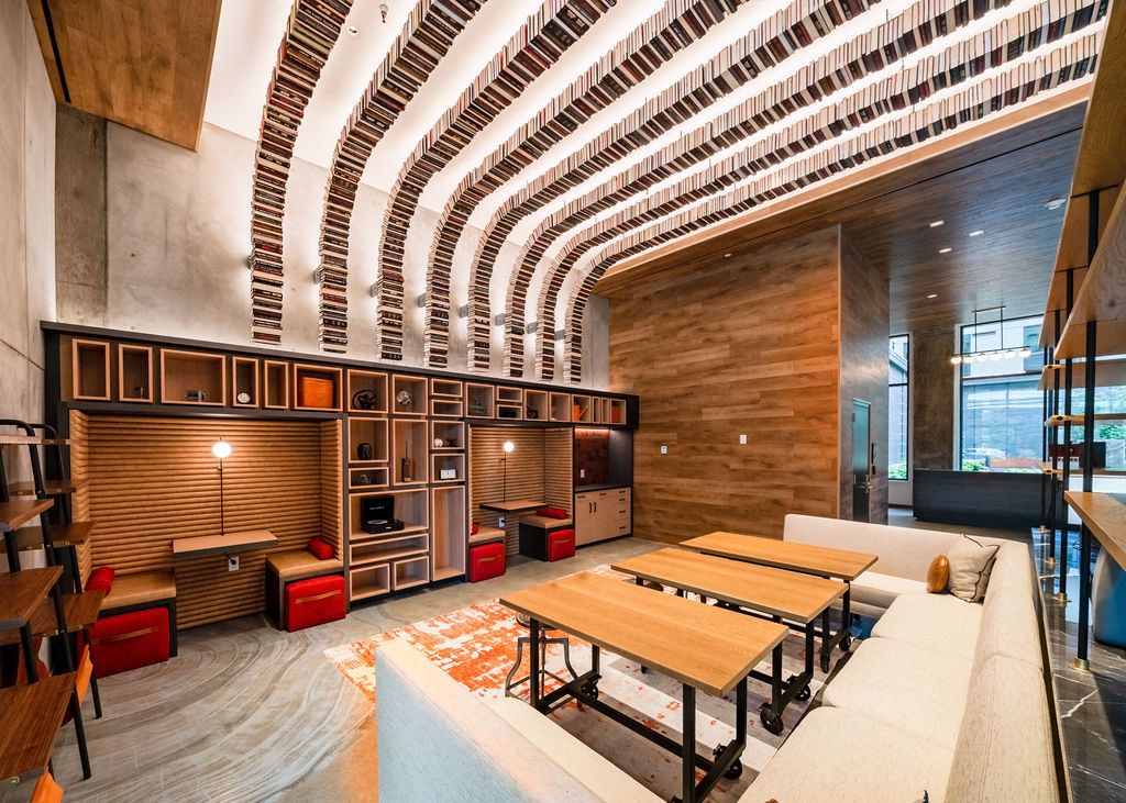 Modern lounge area with wooden accents, curved ceiling, and tables.