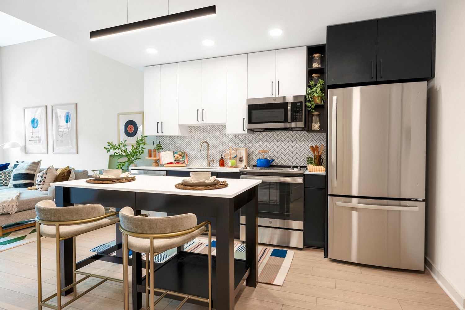 Modern kitchen with a stainless steel fridge, island, and stylish decor.