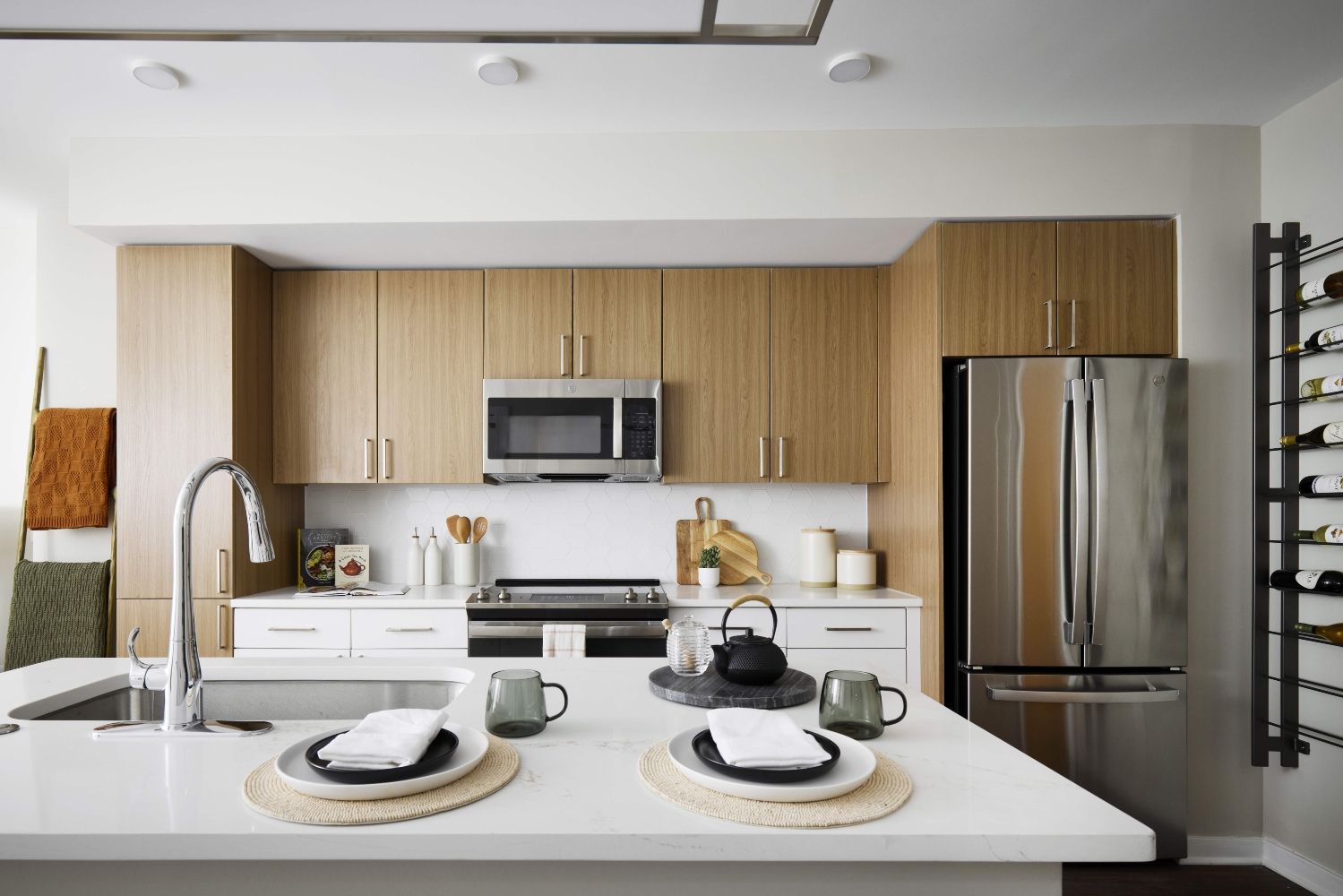 With two-tone kitchen cabinets in wood grain and white with hexagonal white tile backsplash