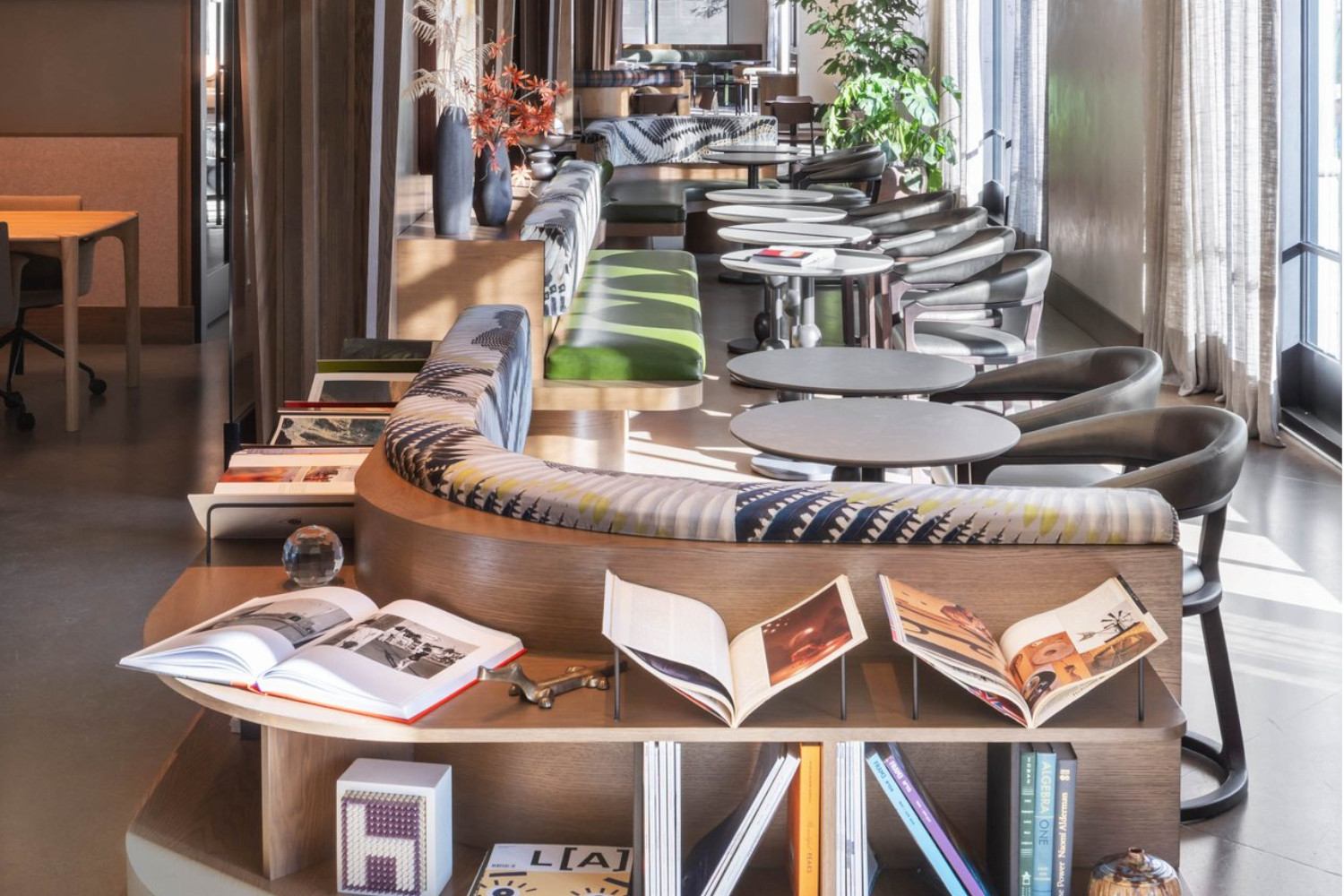 Stylish cafe interior with seating, tables, and shelves of books.