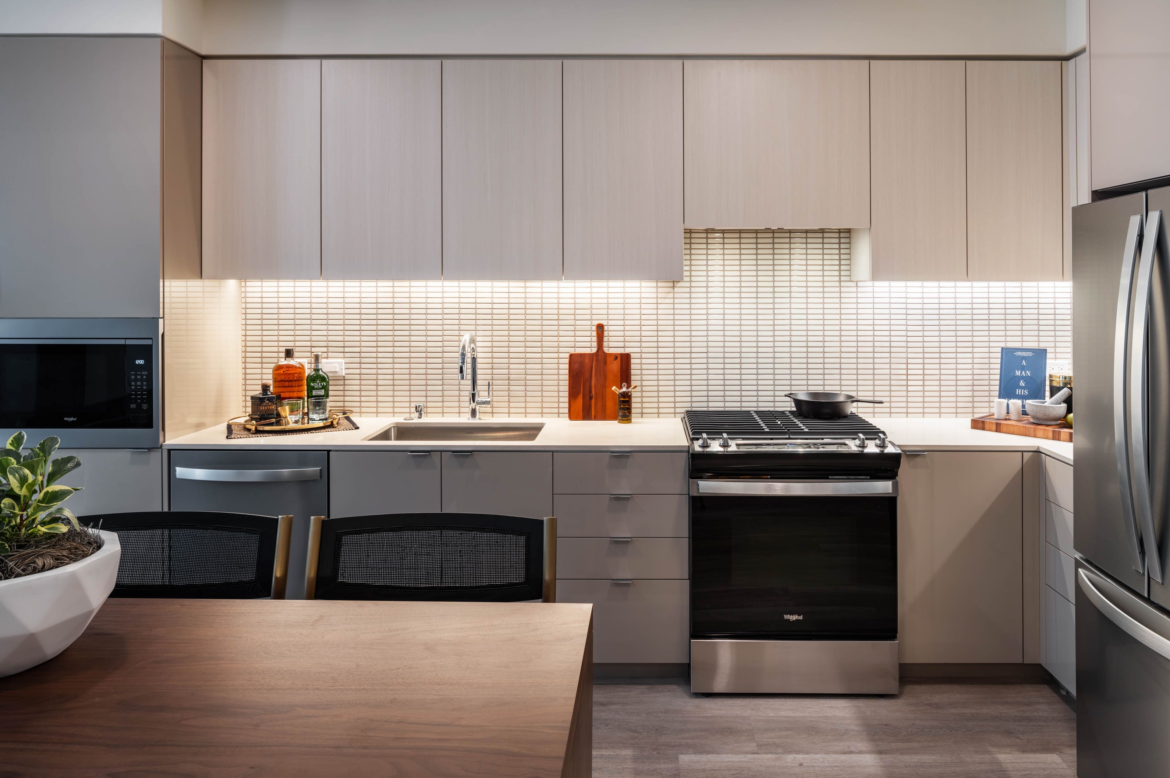 Modern kitchen with sleek cabinets, stainless appliances, and warm lighting.