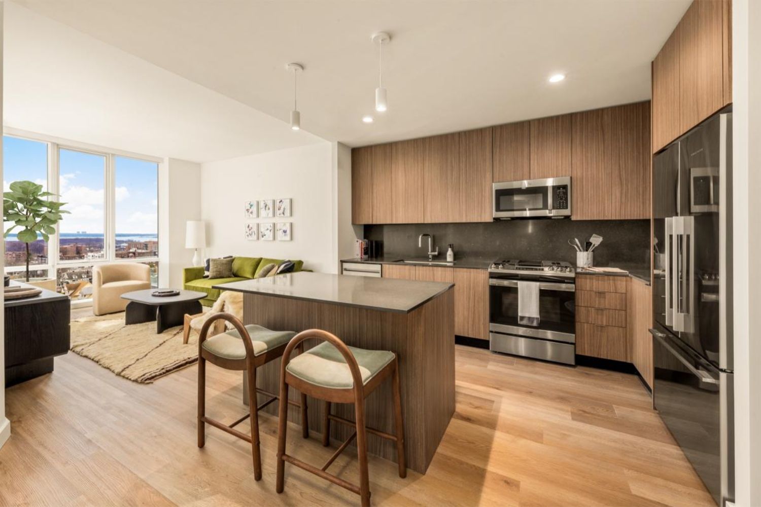 Modern kitchen with wood cabinetry, stainless steel appliances, and a cozy living area.
