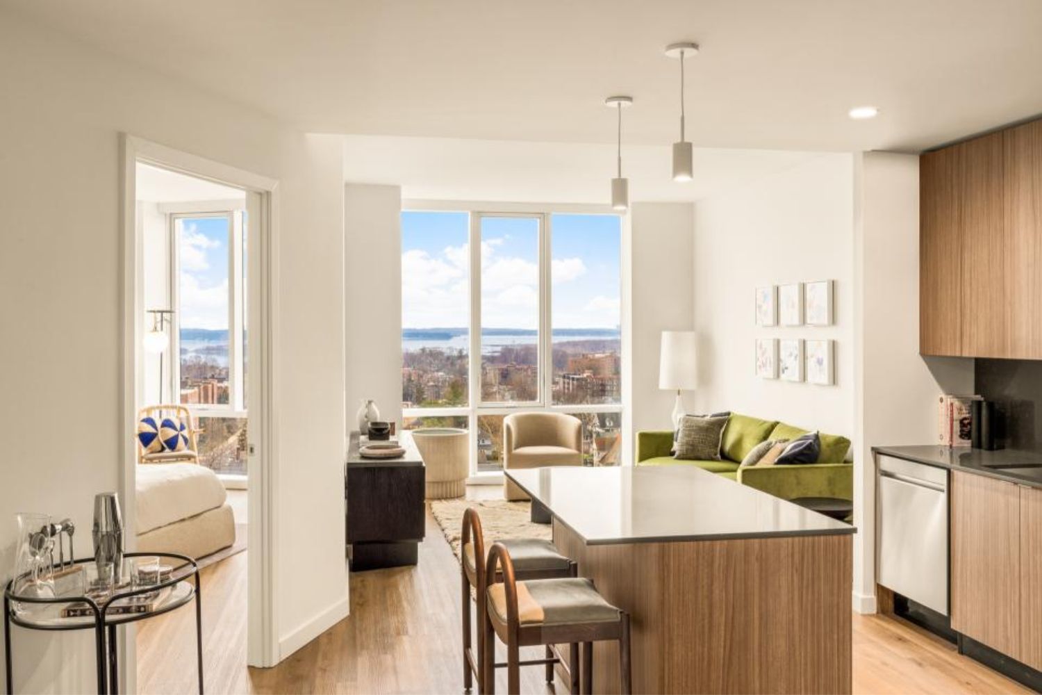 Modern kitchen and living area with large windows showcasing a scenic view.