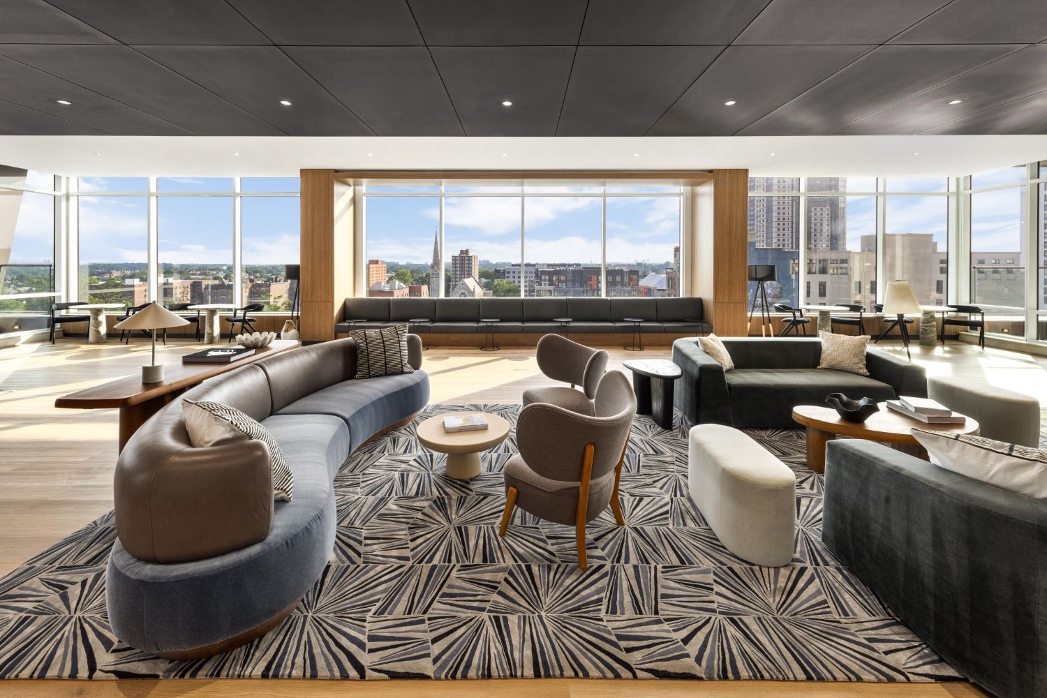 Modern living room with large windows, stylish furniture, and a city view.