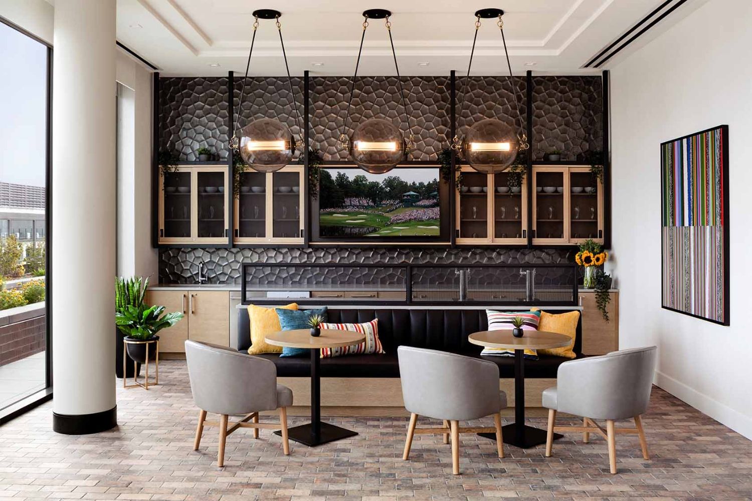 Modern interior with a black couch, light fixtures, and a dining table surrounded by chairs.