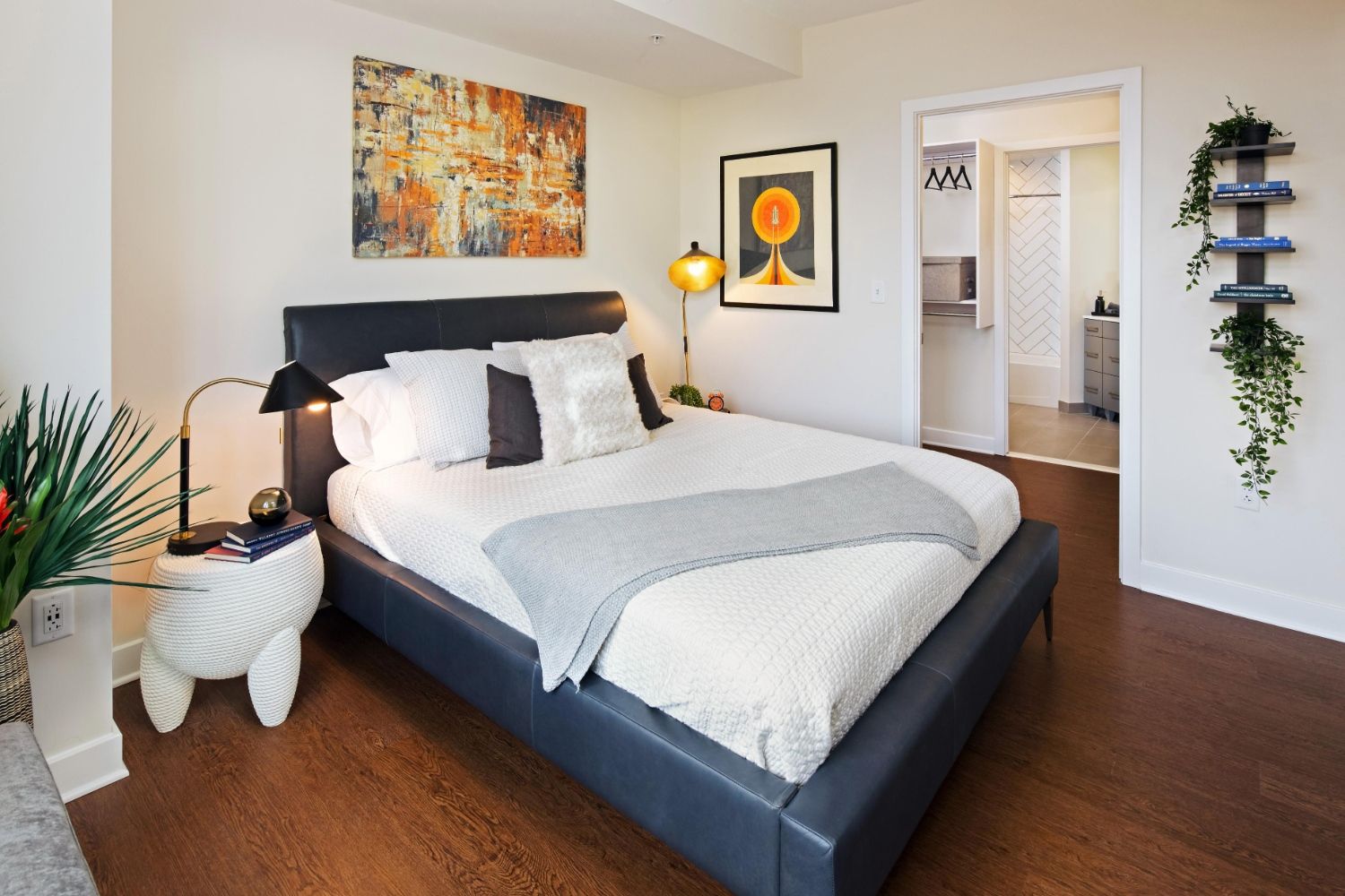 Modern bedroom with upholstered bed, abstract art, and view into walk-in closet