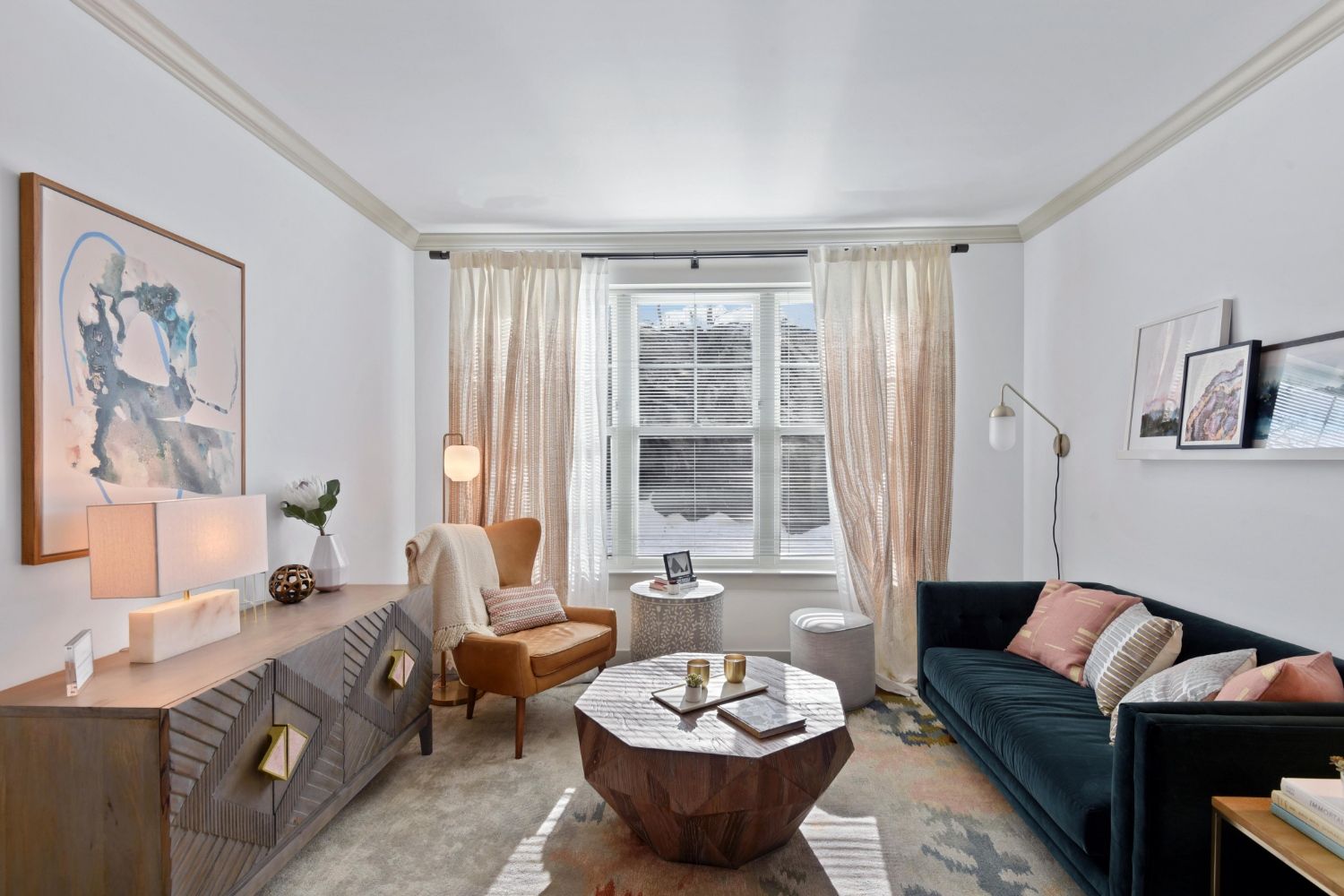 Cozy living room with velvet sofa, wood accents, abstract art, and sunlit window curtains
