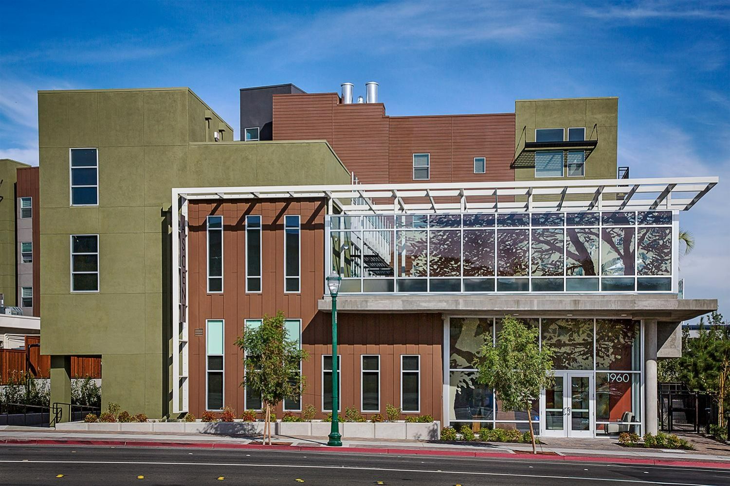 Modern multi-story building with a glass facade and green accents.