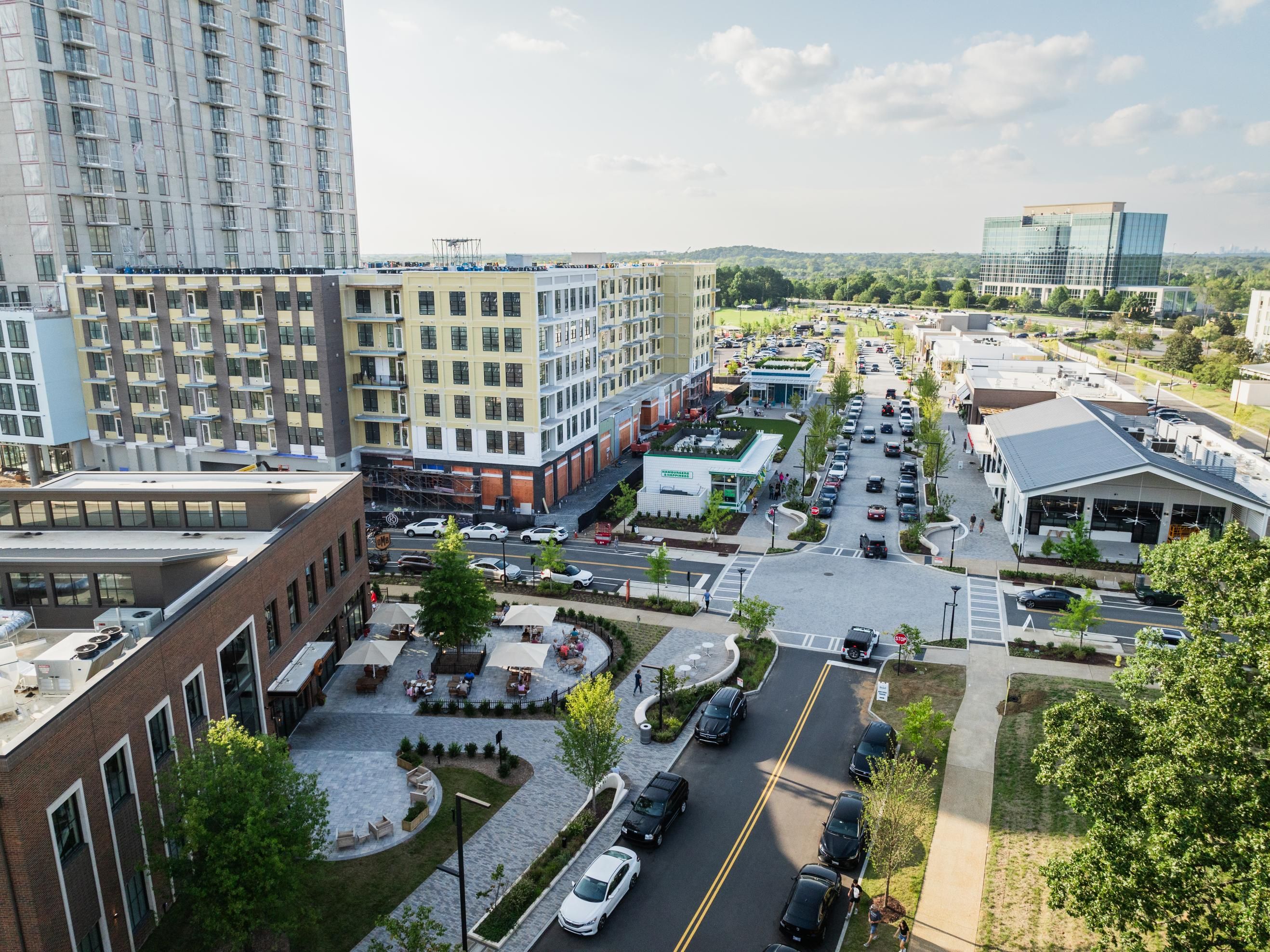 Aerial view of a modern urban area with buildings, roads, and parked cars.