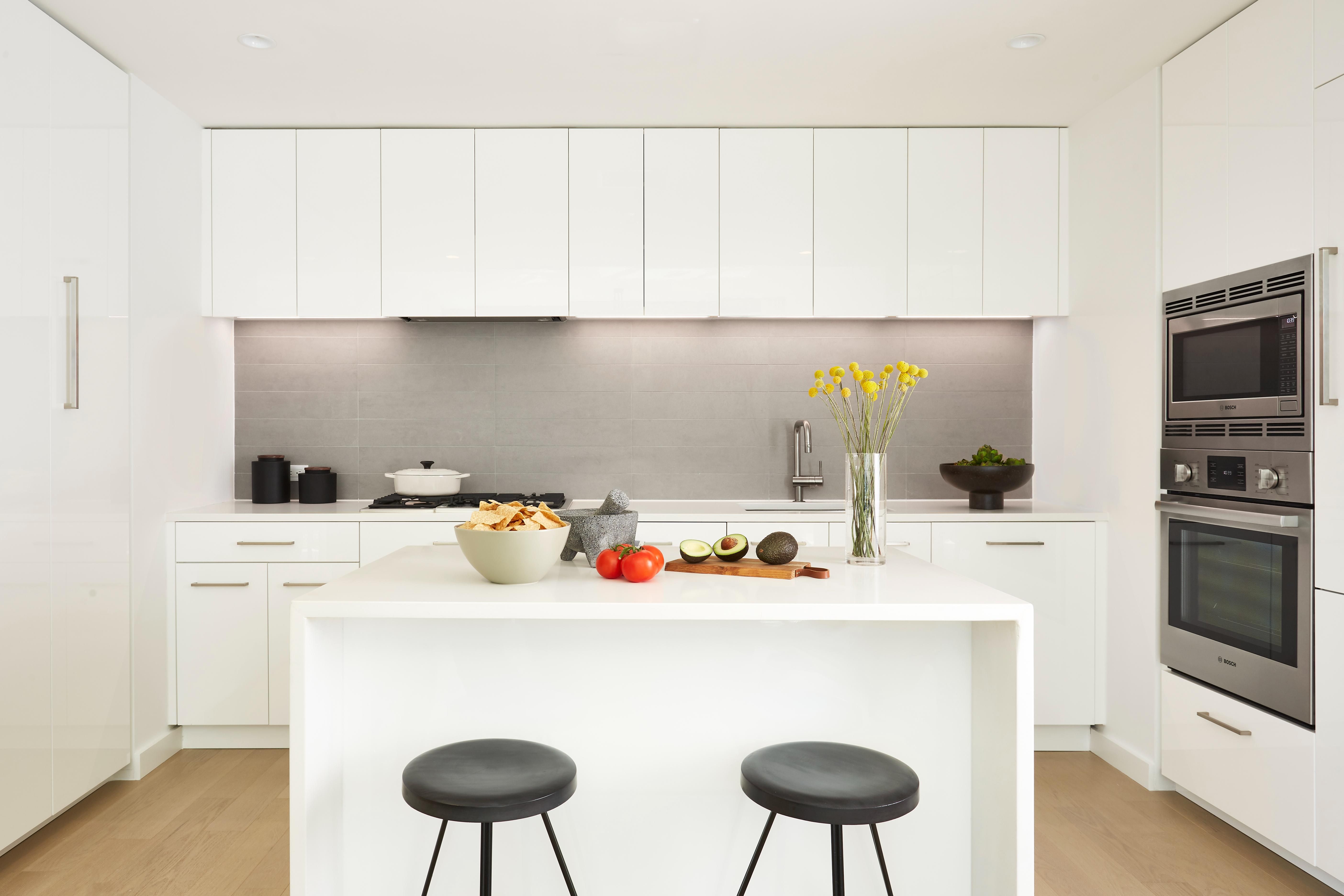 Kitchen showing island and all white cabinetry