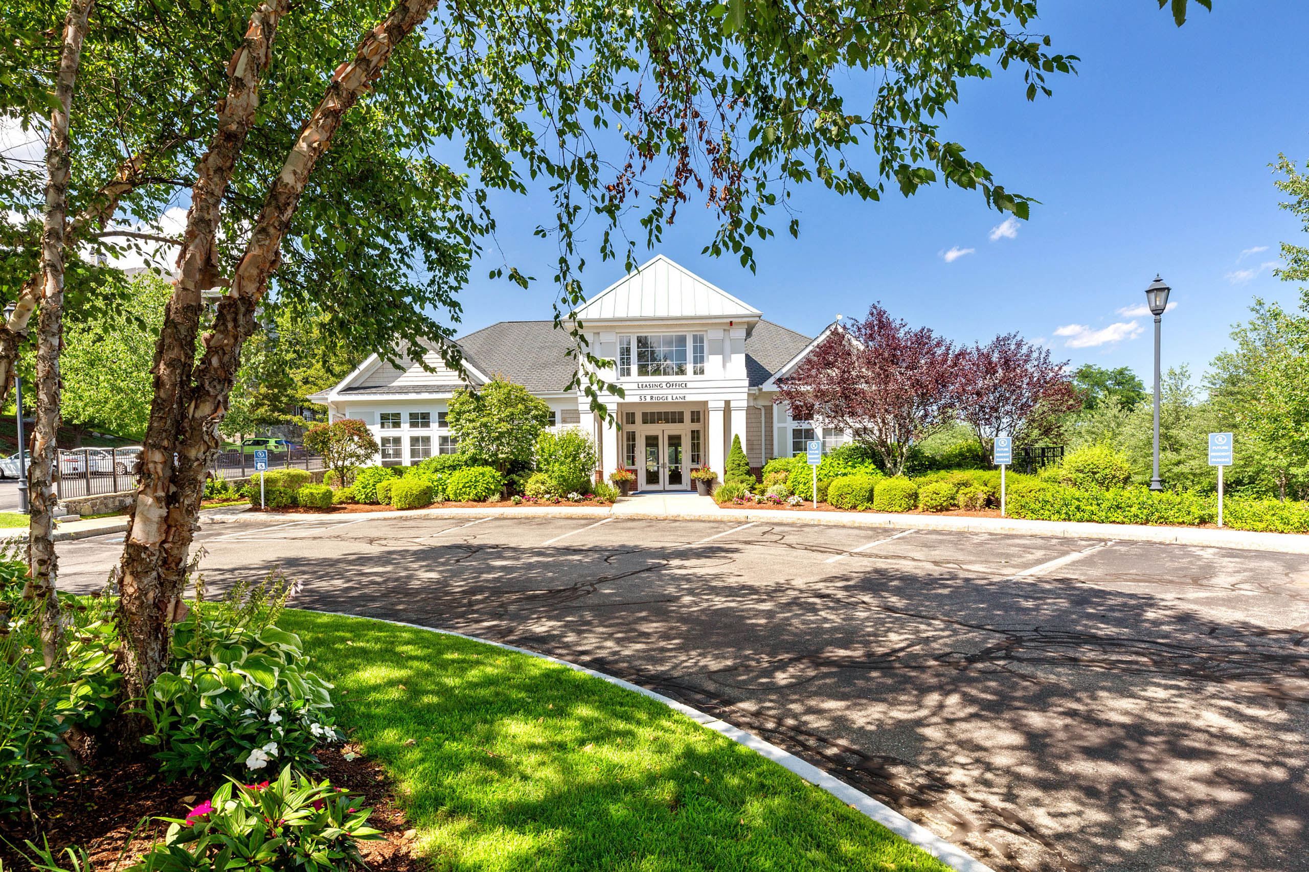 A modern building with a landscaped entrance under clear blue skies.