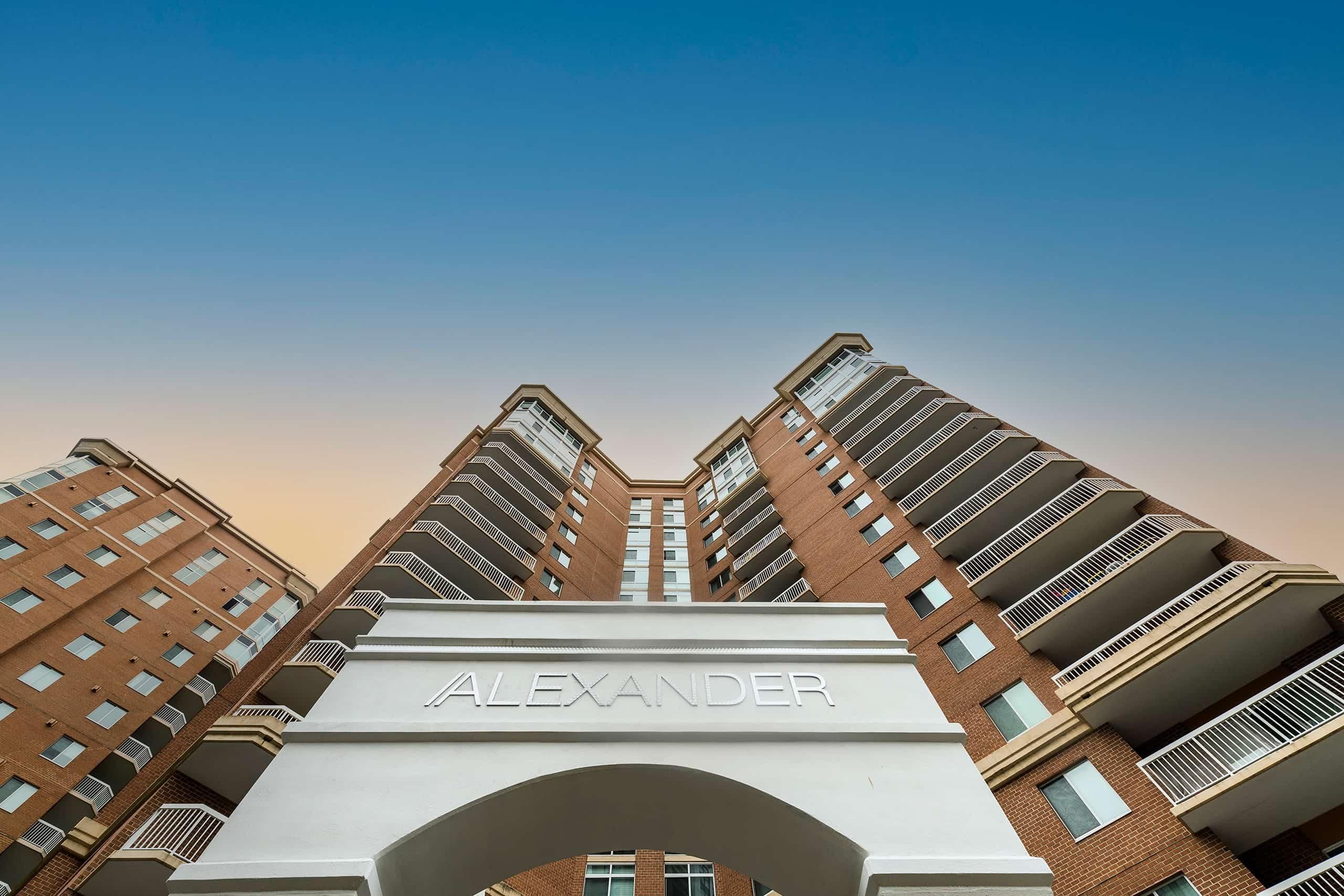 Modern brick apartment building with a clear sky and sunset hues.