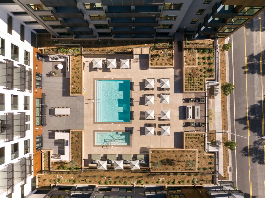 Aerial view of a rectangular pool surrounded by lounge chairs and landscaped areas.