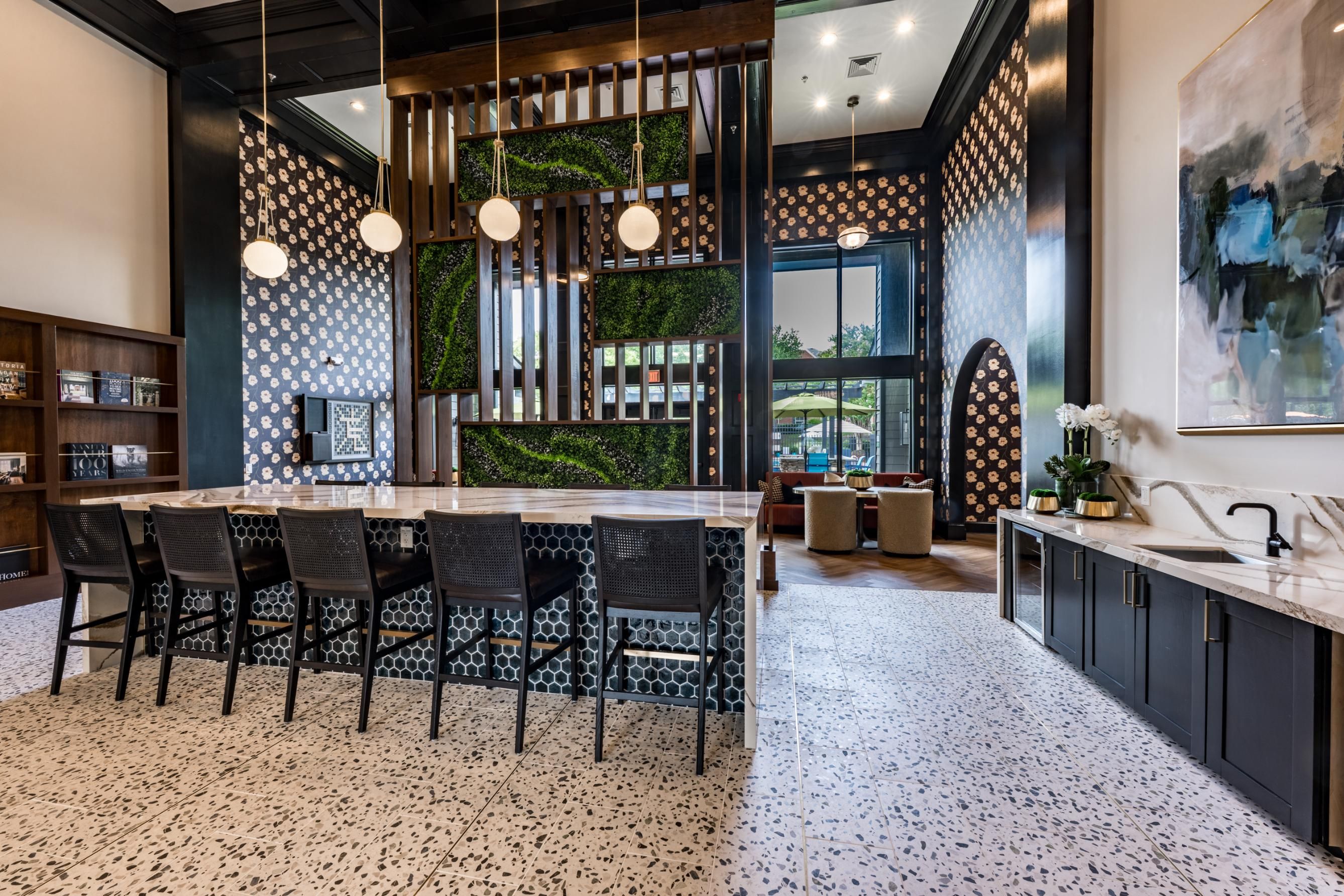 Modern interior with a bar, patterned walls, greenery, and elegant lighting.