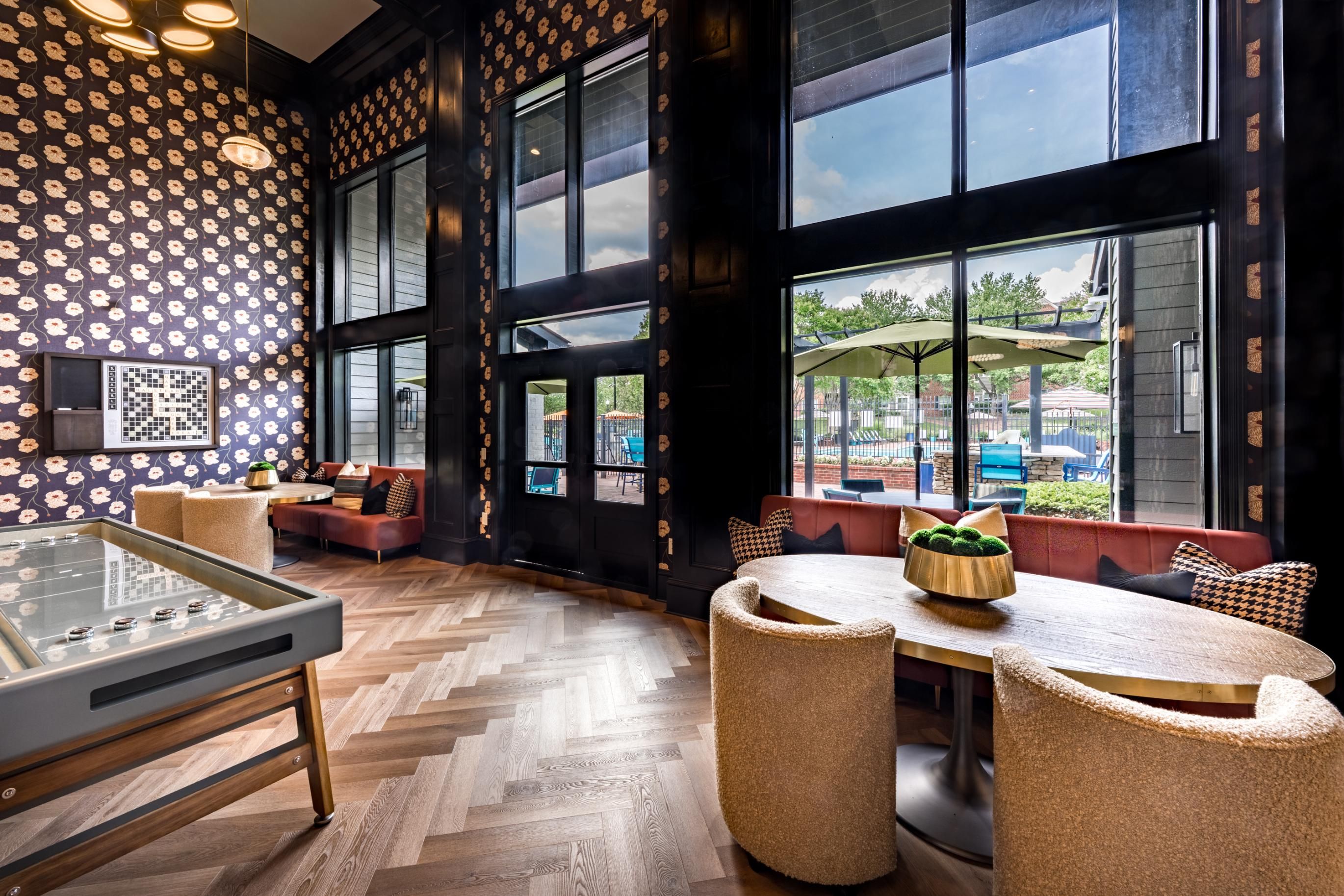 Stylish interior with patterned walls, seating areas, and large windows.