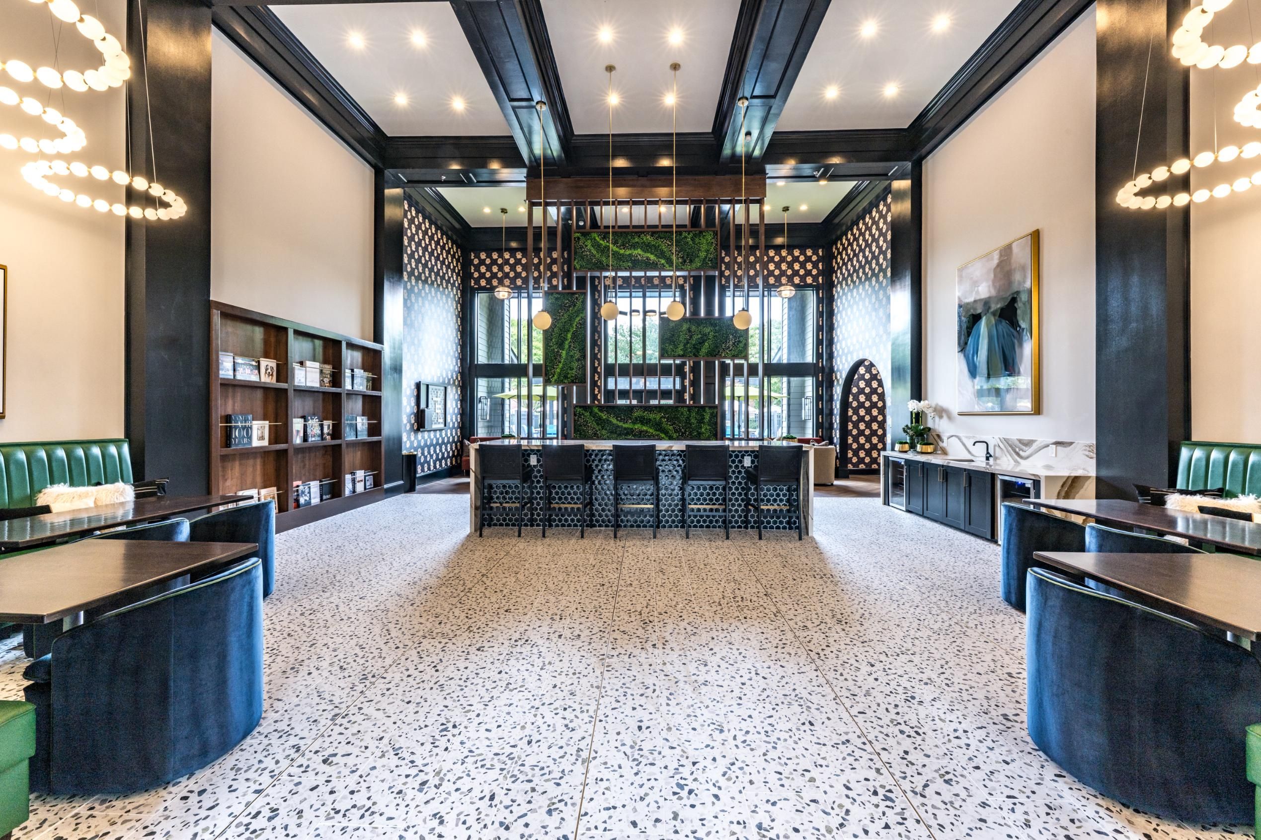 Elegant modern interior with high ceilings, green accents, and stylish furnishings.