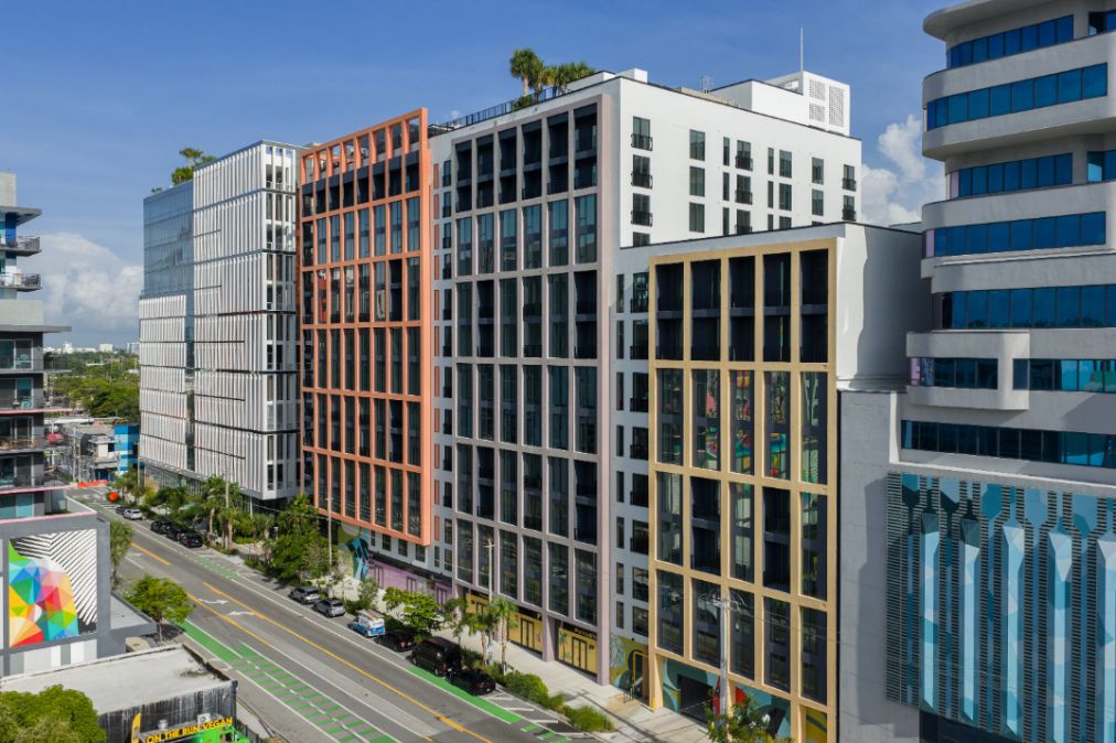 Modern buildings with varying architectural styles along a urban street.