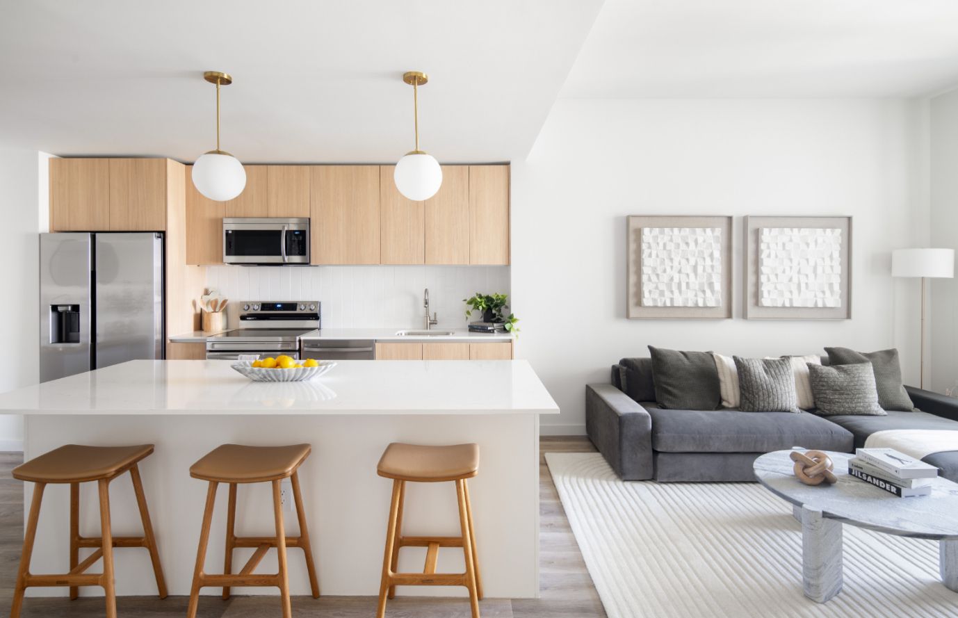 Modern kitchen and living room with light wood tones and stylish decor.