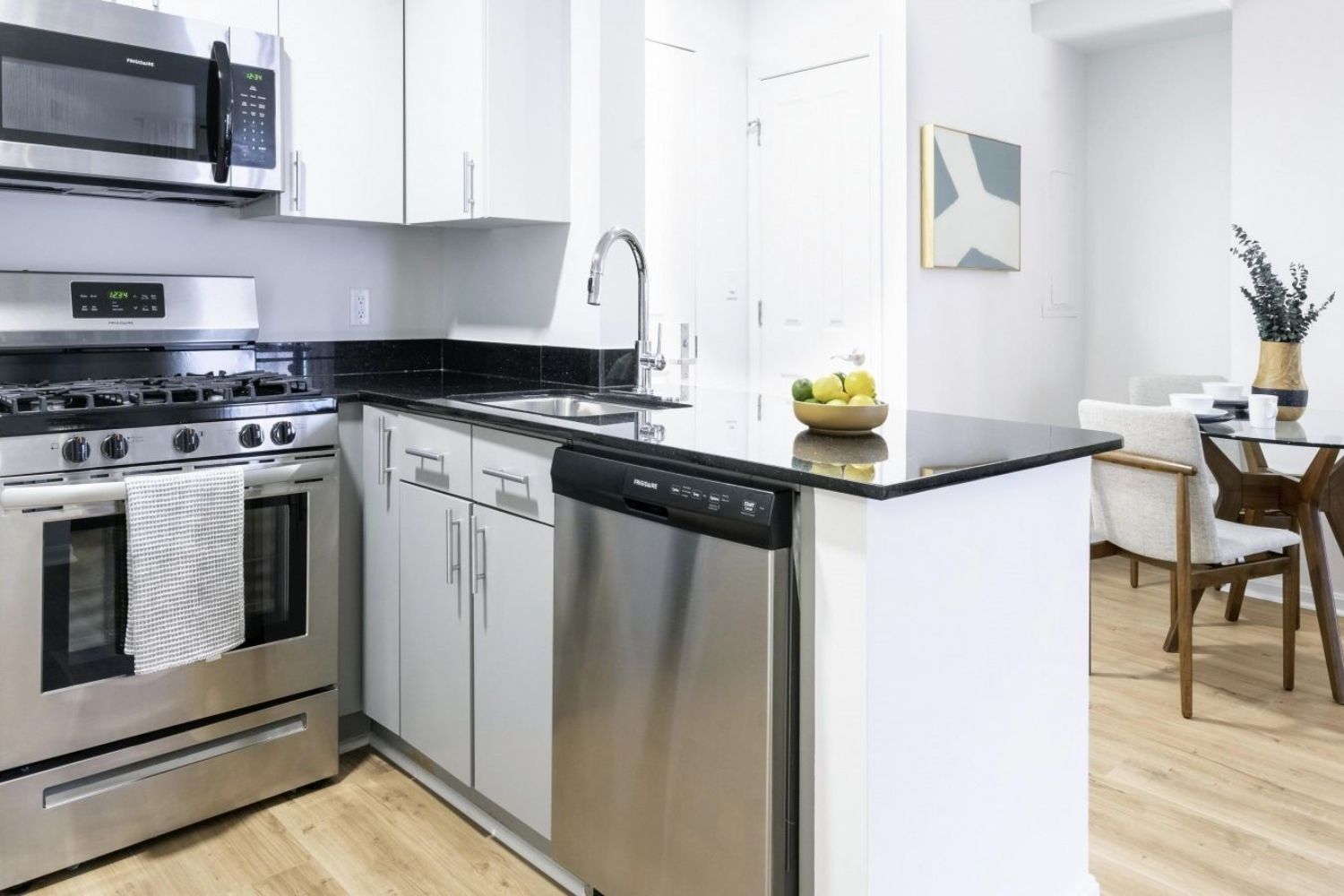 Modern kitchen with stainless steel appliances and a black countertop.