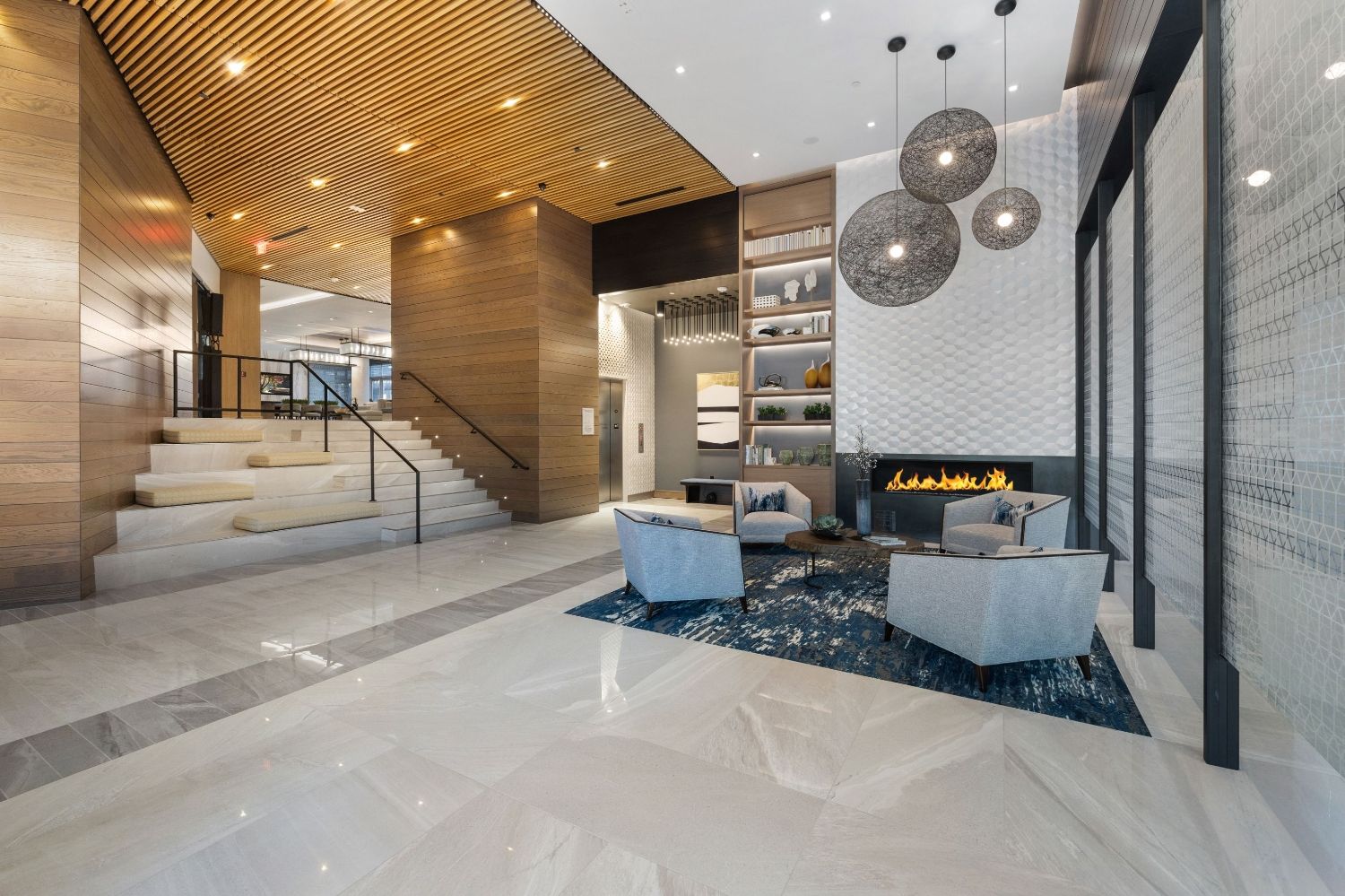 Modern lobby with wooden accents, a fireplace, and stylish seating areas.