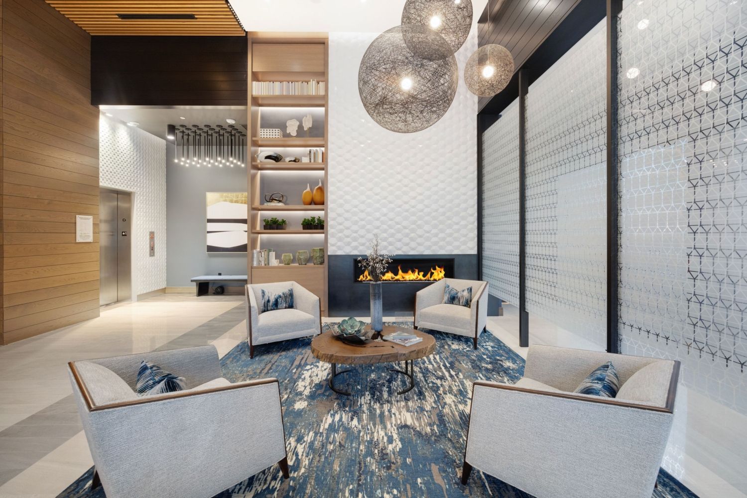 Modern lobby with three armchairs, a coffee table, and decorative lighting.