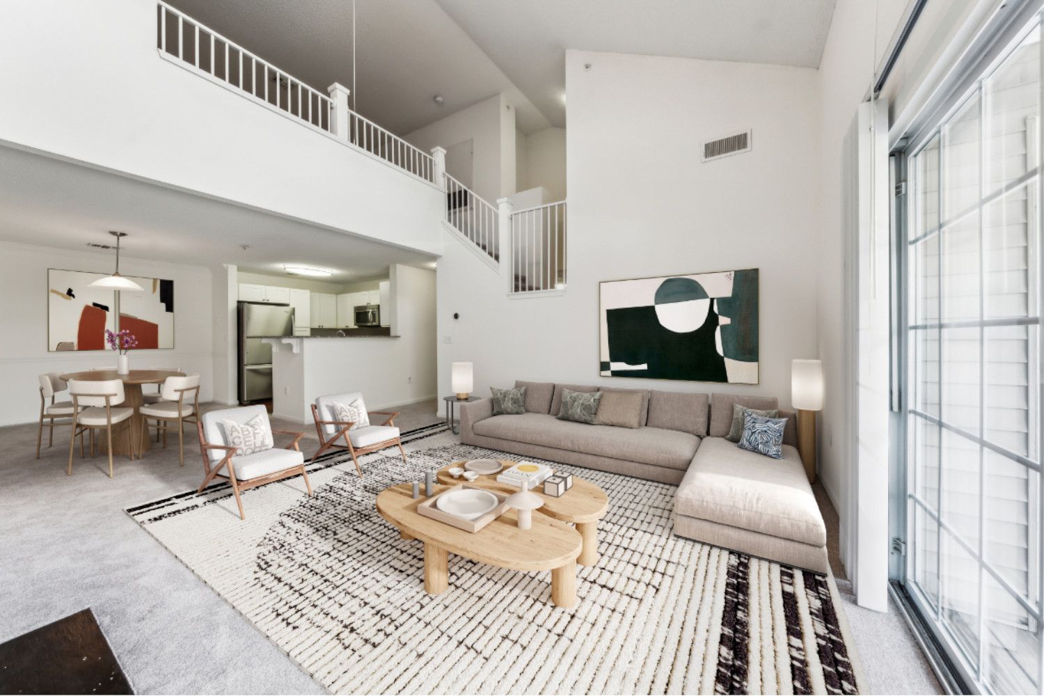 Spacious, modern living room with a sectional sofa, rug, and wall-mounted artwork.