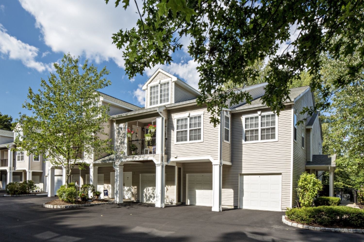 Modern residential building with trees and blue sky.