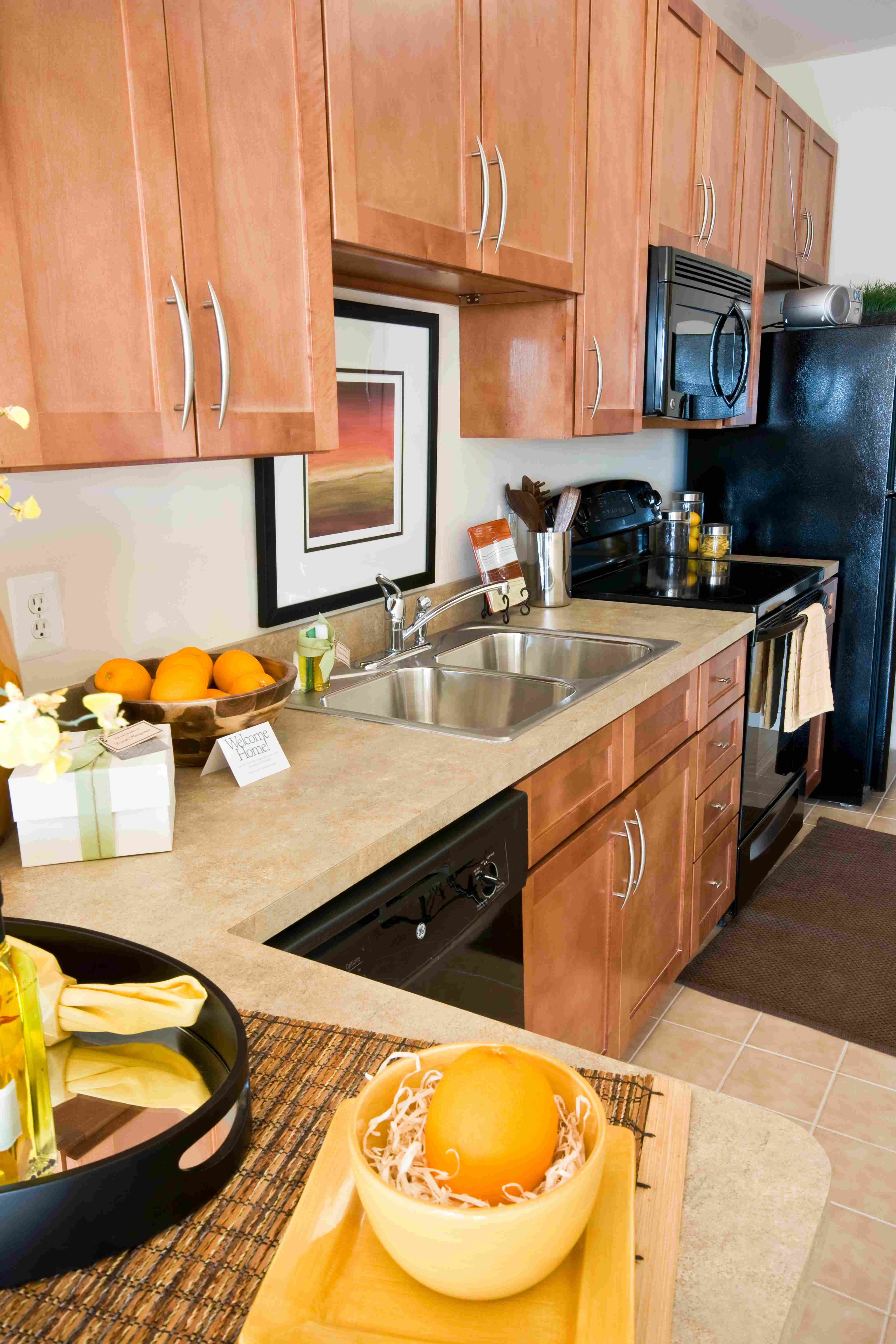 Modern kitchen with wooden cabinets, countertop, sink, and appliances.