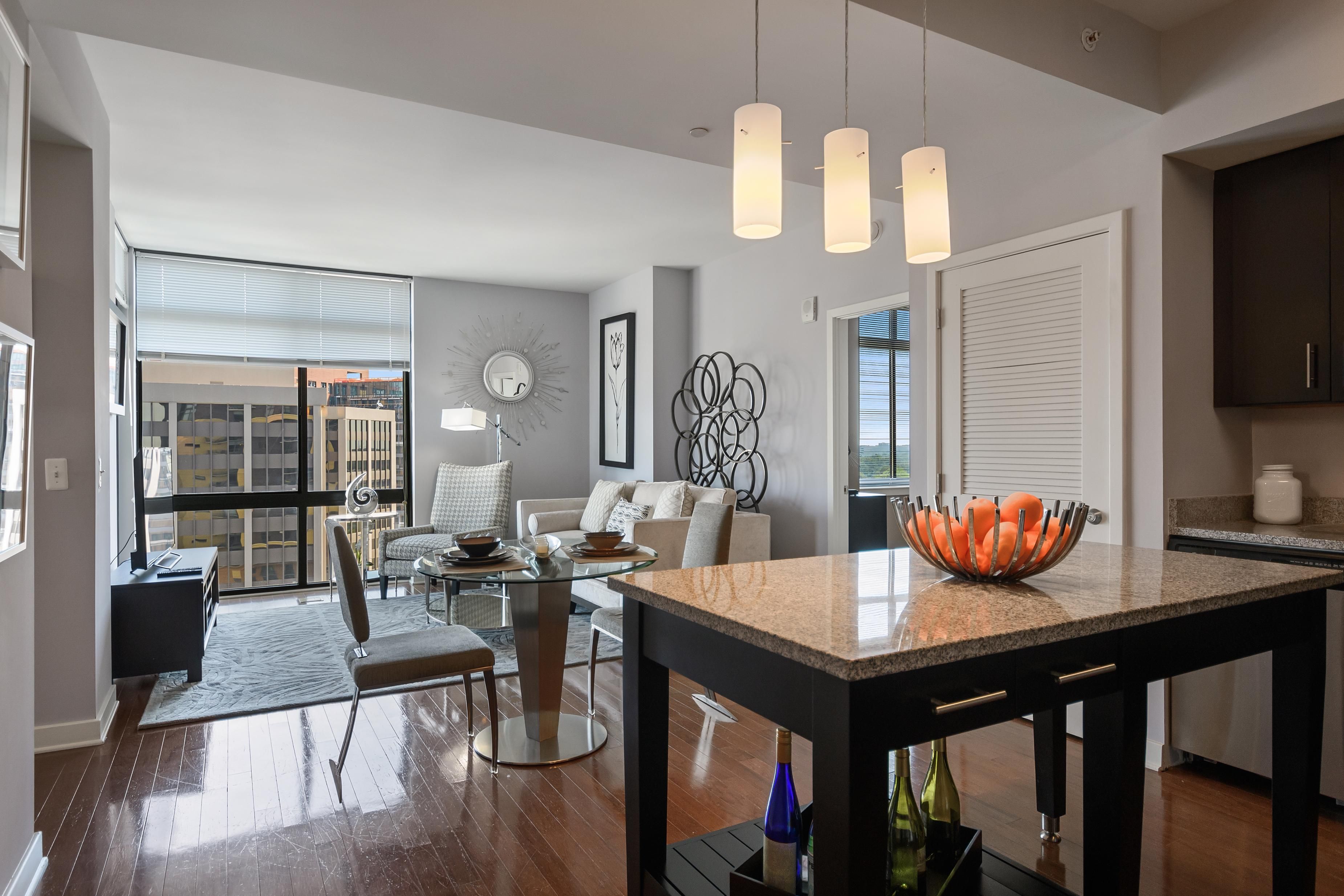 Modern living room and dining area with natural light and elegant furnishings.