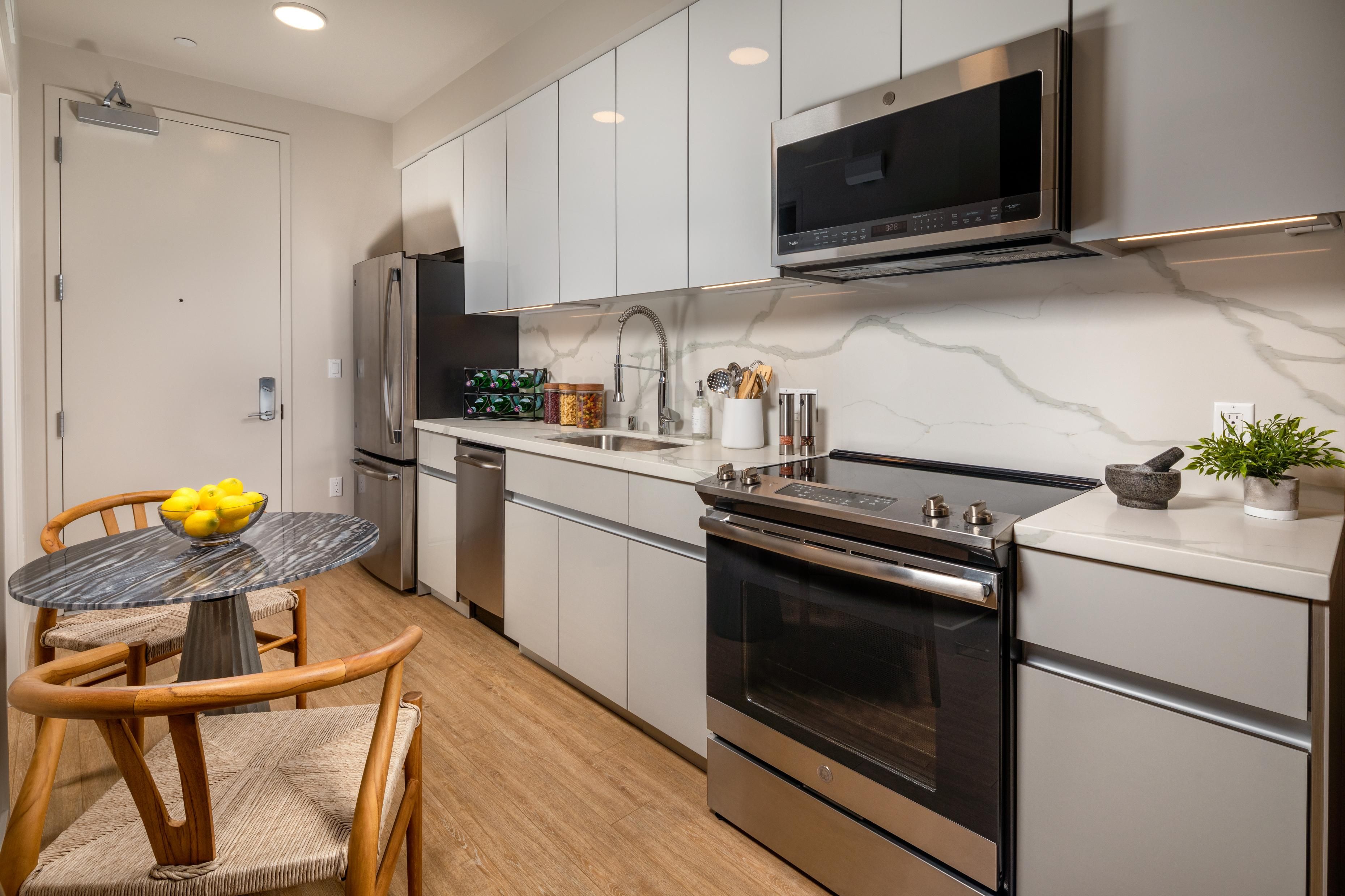 Modern kitchen with stainless steel appliances and a round dining table.