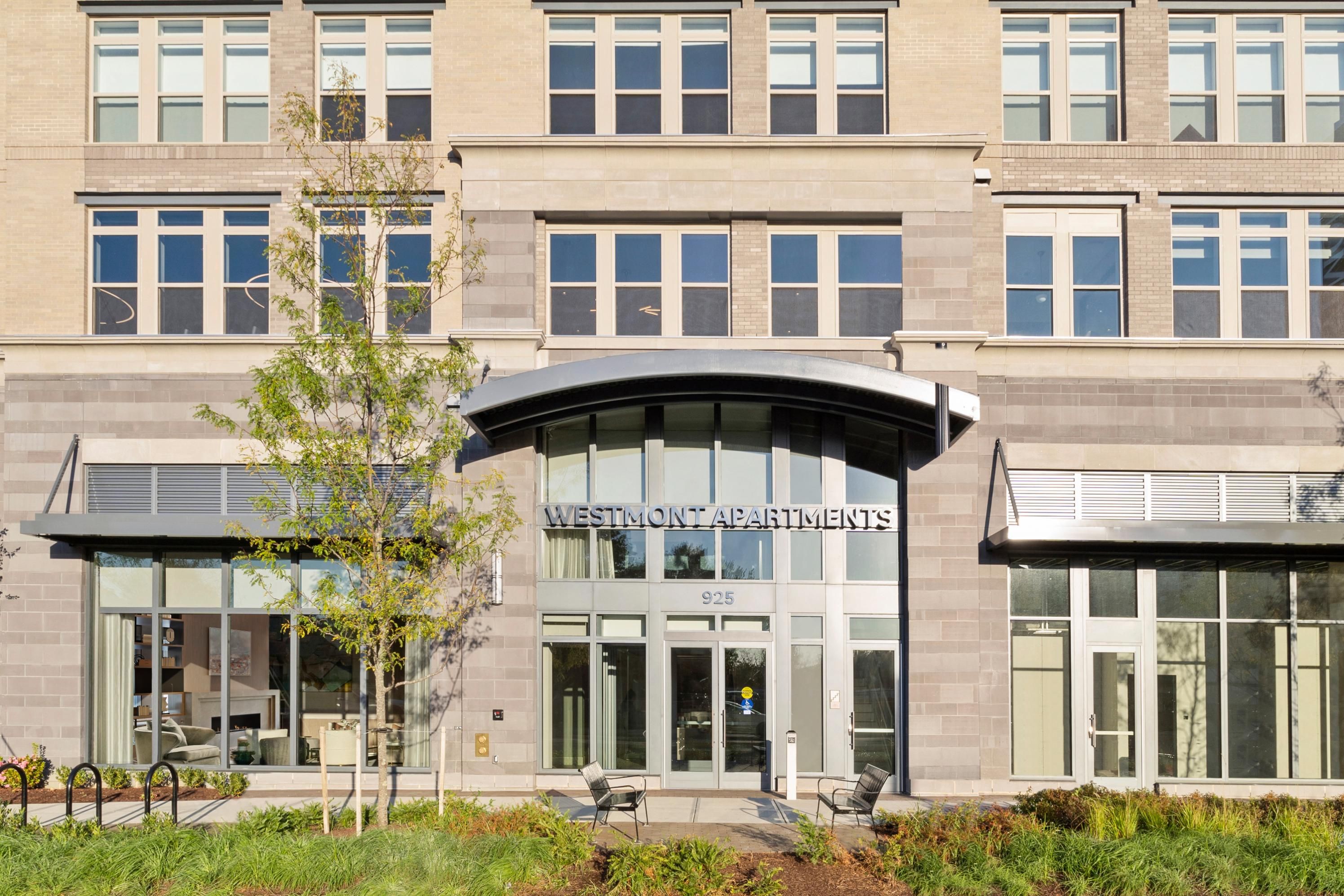 Modern building entrance with large windows and a curved awning.
