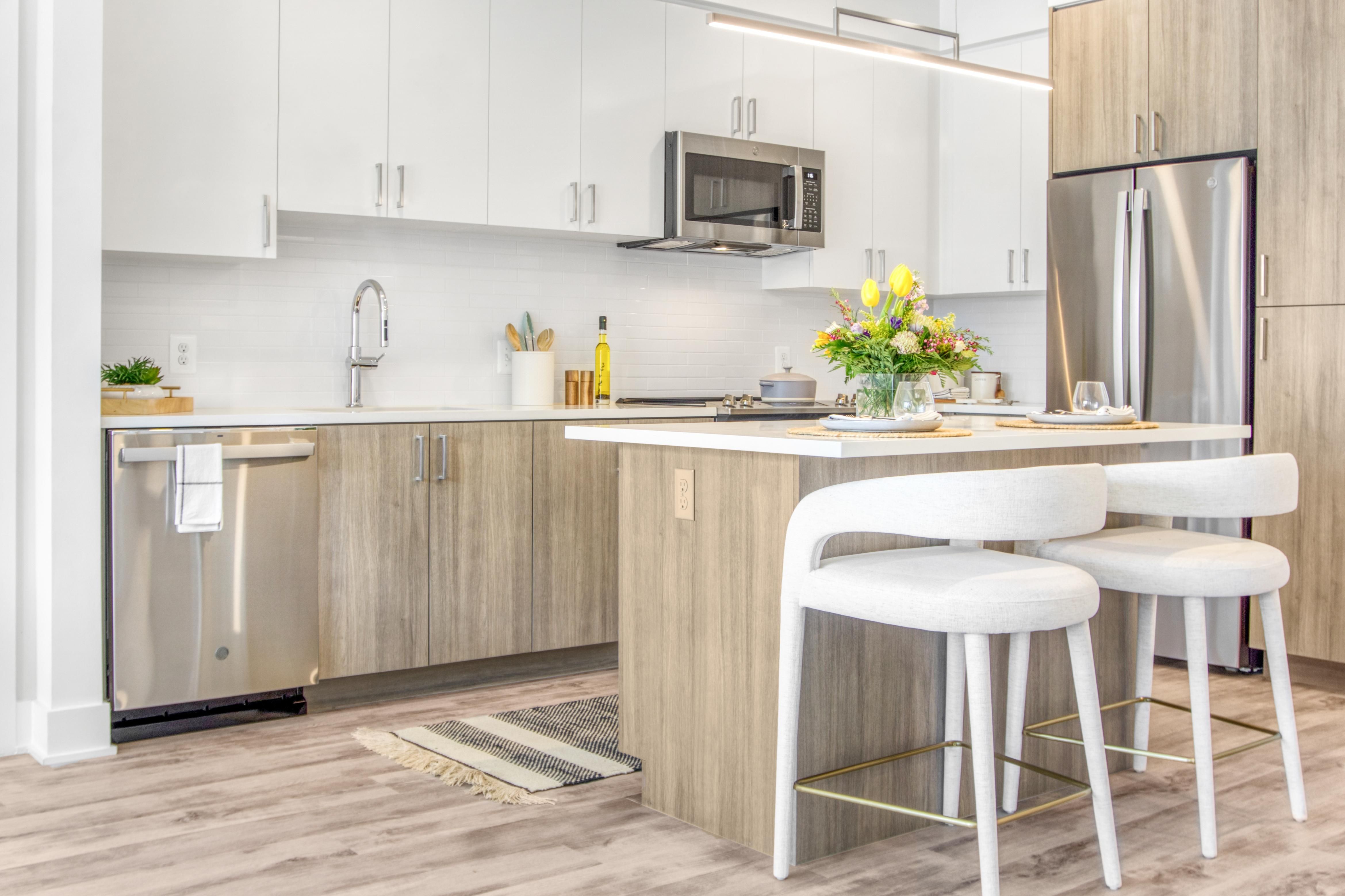 Modern kitchen with white cabinets, stainless steel appliances, and a wooden island.