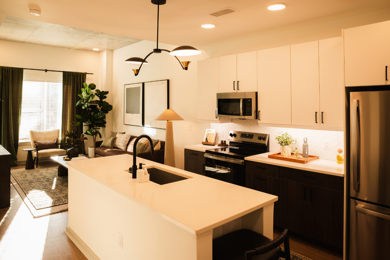Modern kitchen with white cabinets and stainless steel appliances.