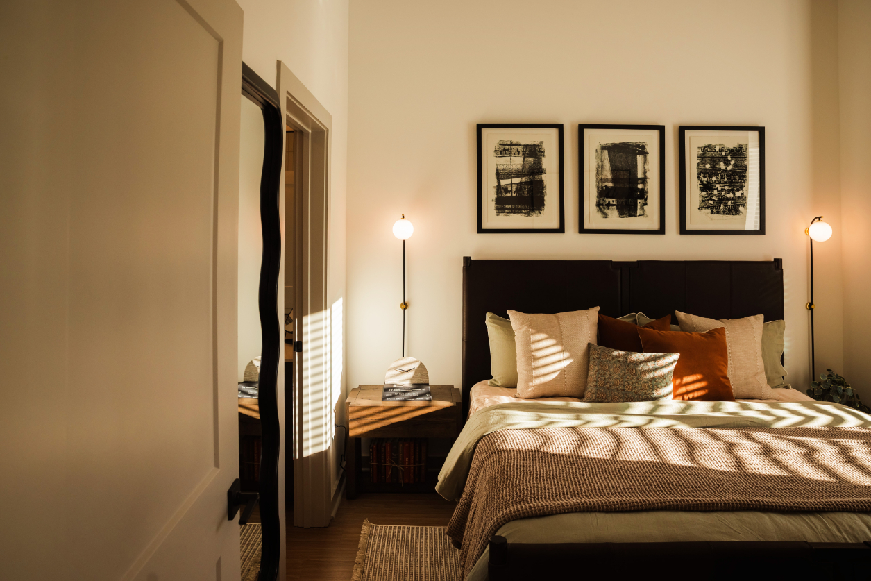 Cozy bedroom with a bed, pillows, and framed artworks on the wall.