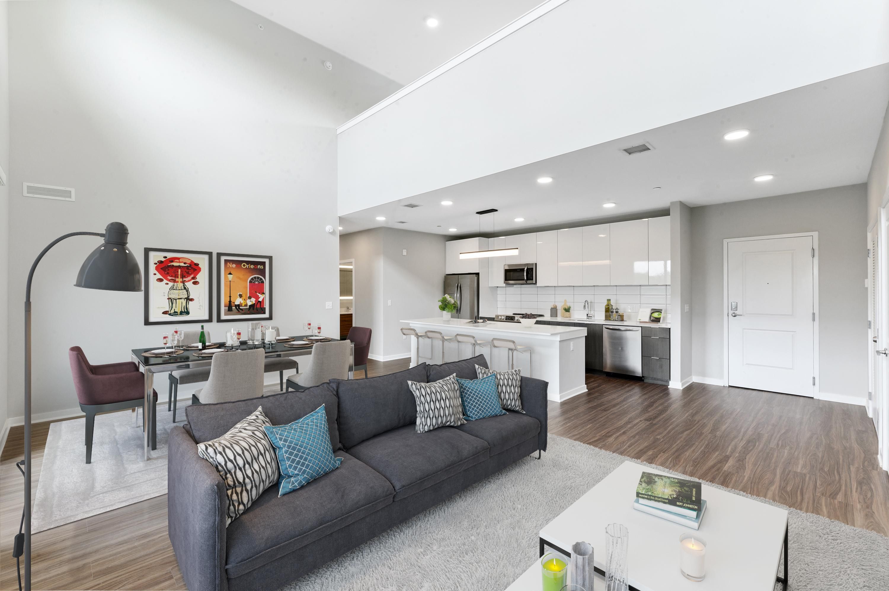 Modern open-concept living space featuring a sofa, dining area, and kitchen.