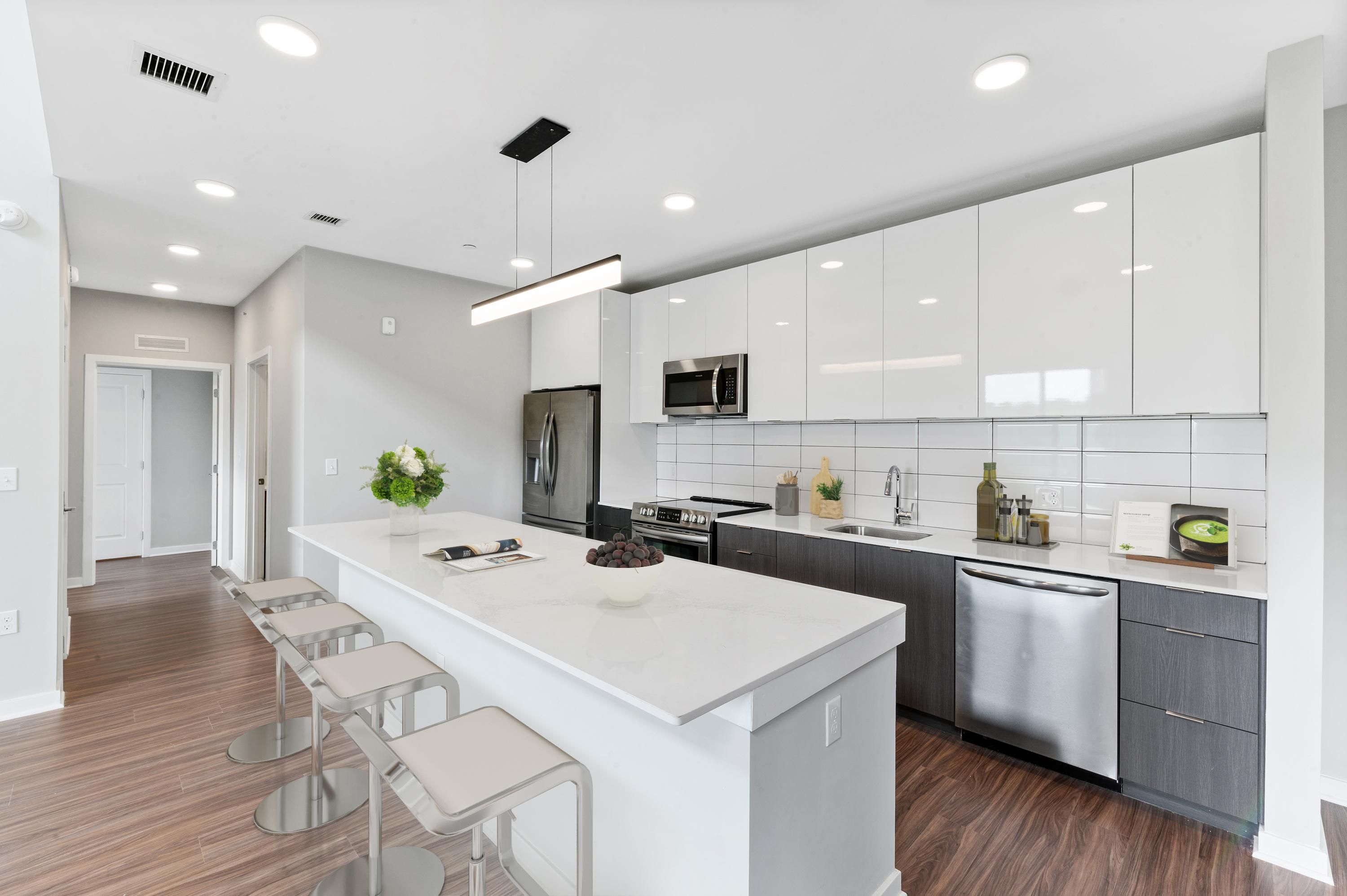 Modern kitchen with white cabinets, gray accents, and a central island with seating.