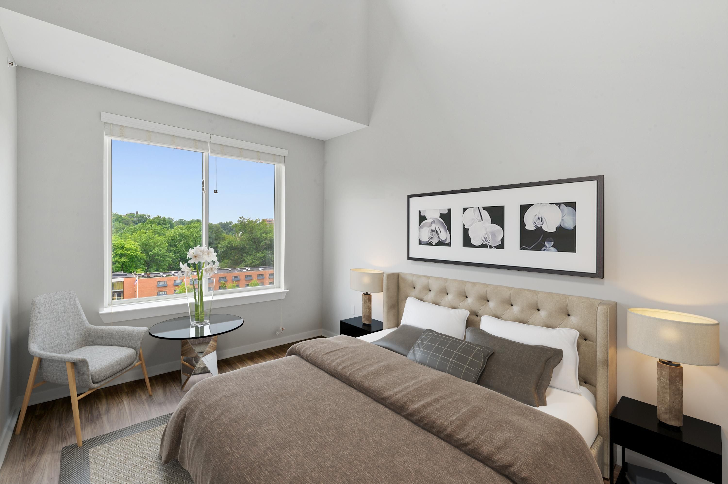 Cozy bedroom with large window, bed, and minimalist decor.