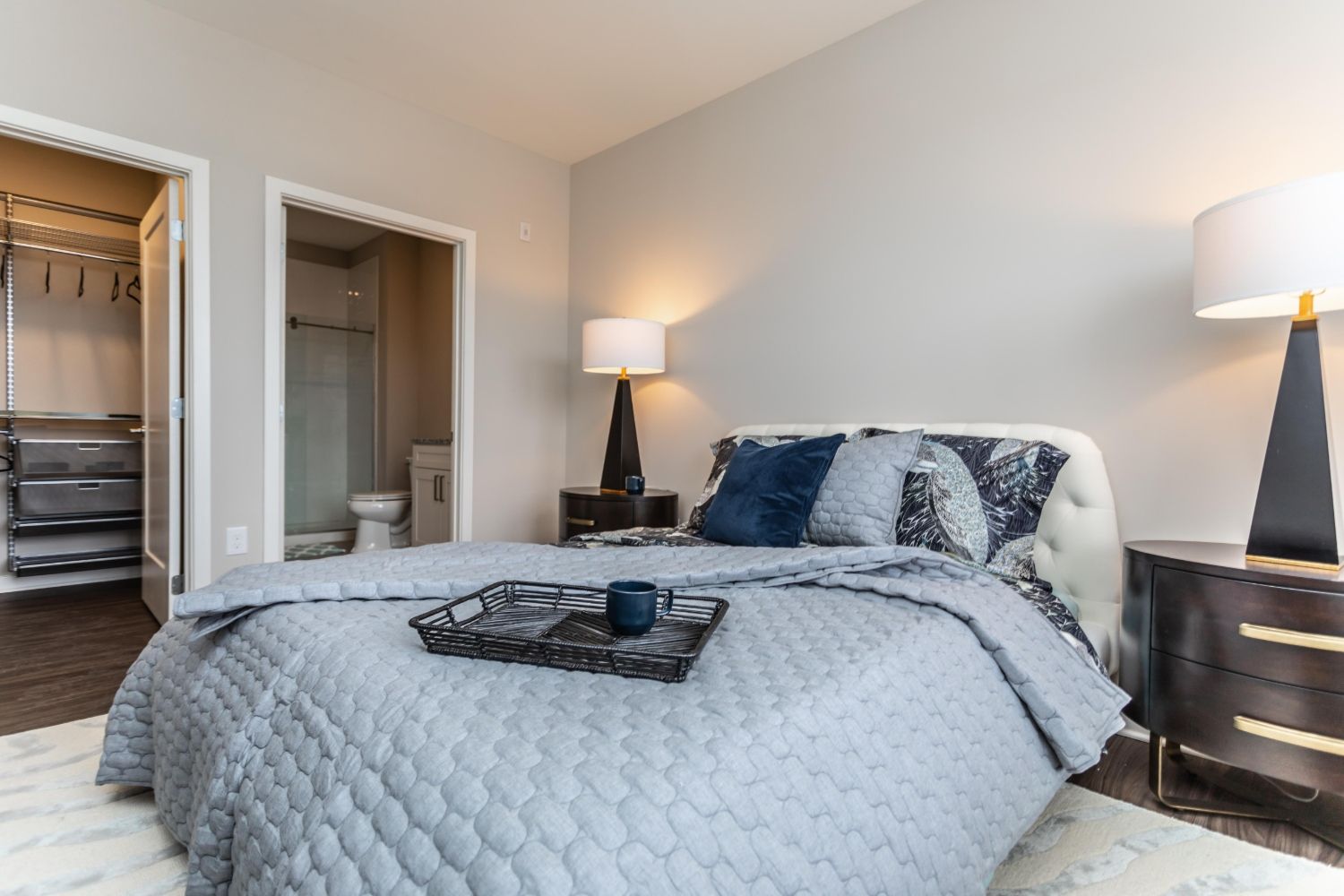 Cozy bedroom featuring a large bed, nightstands, and adjacent bathroom access.