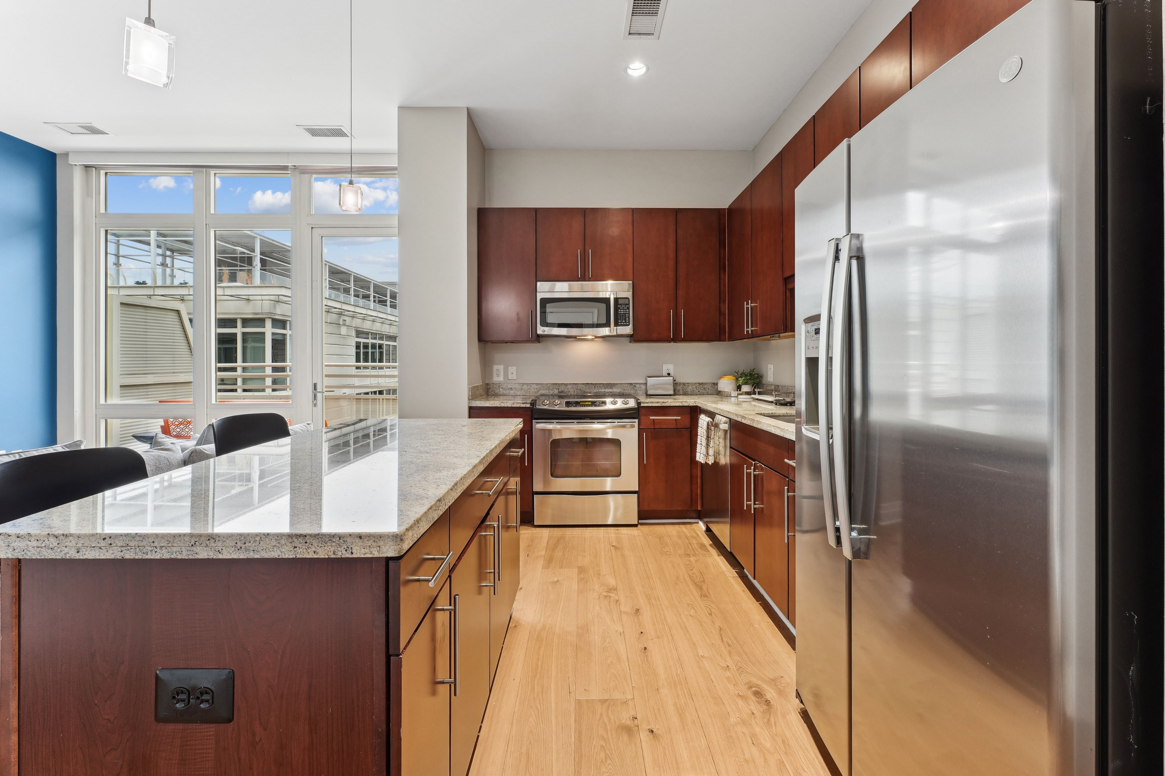 Modern kitchen featuring wood cabinets, stainless steel appliances, and a bright atmosphere.