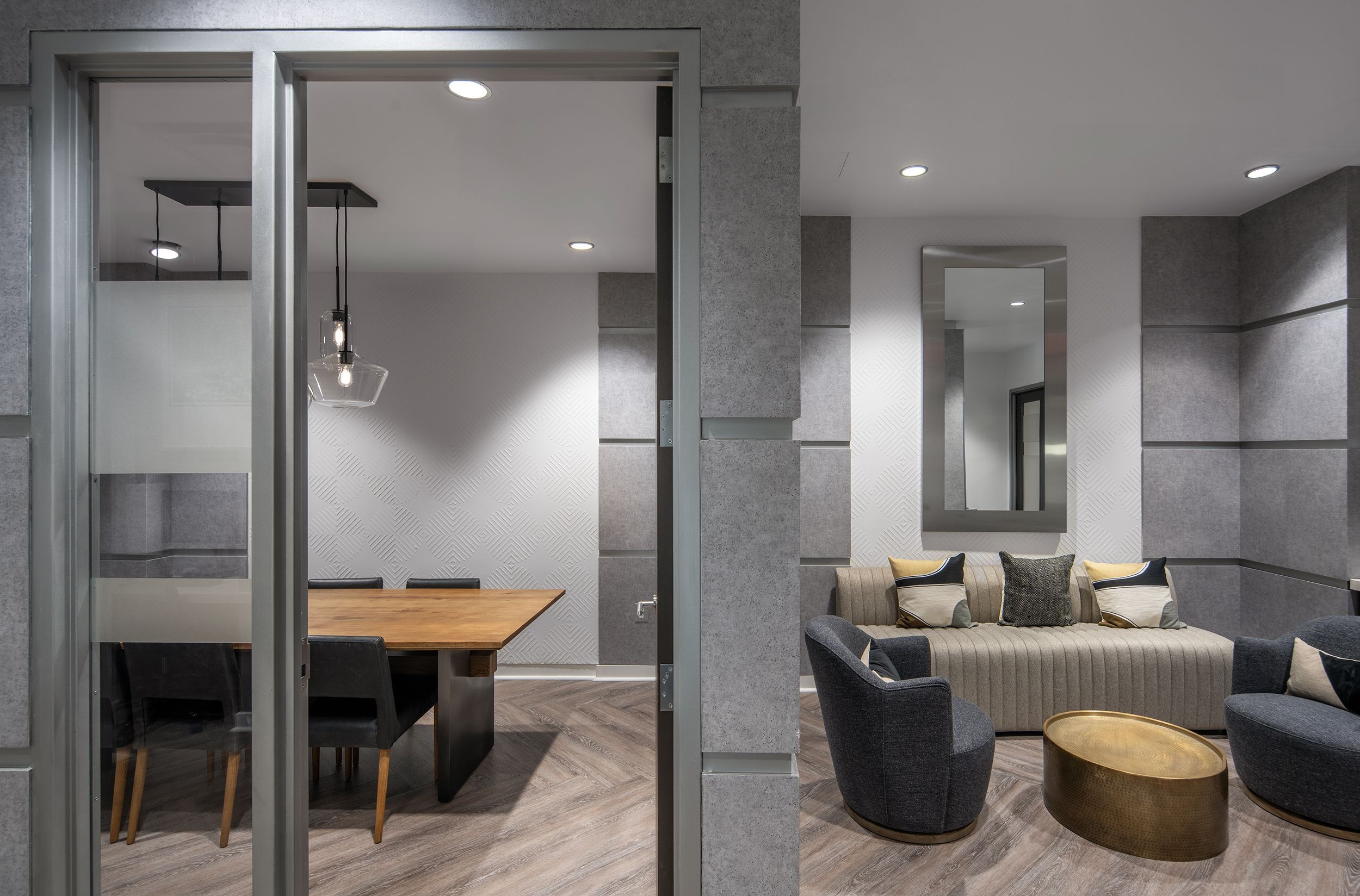 Modern living area with gray walls, a dining table, and a cozy seating arrangement.