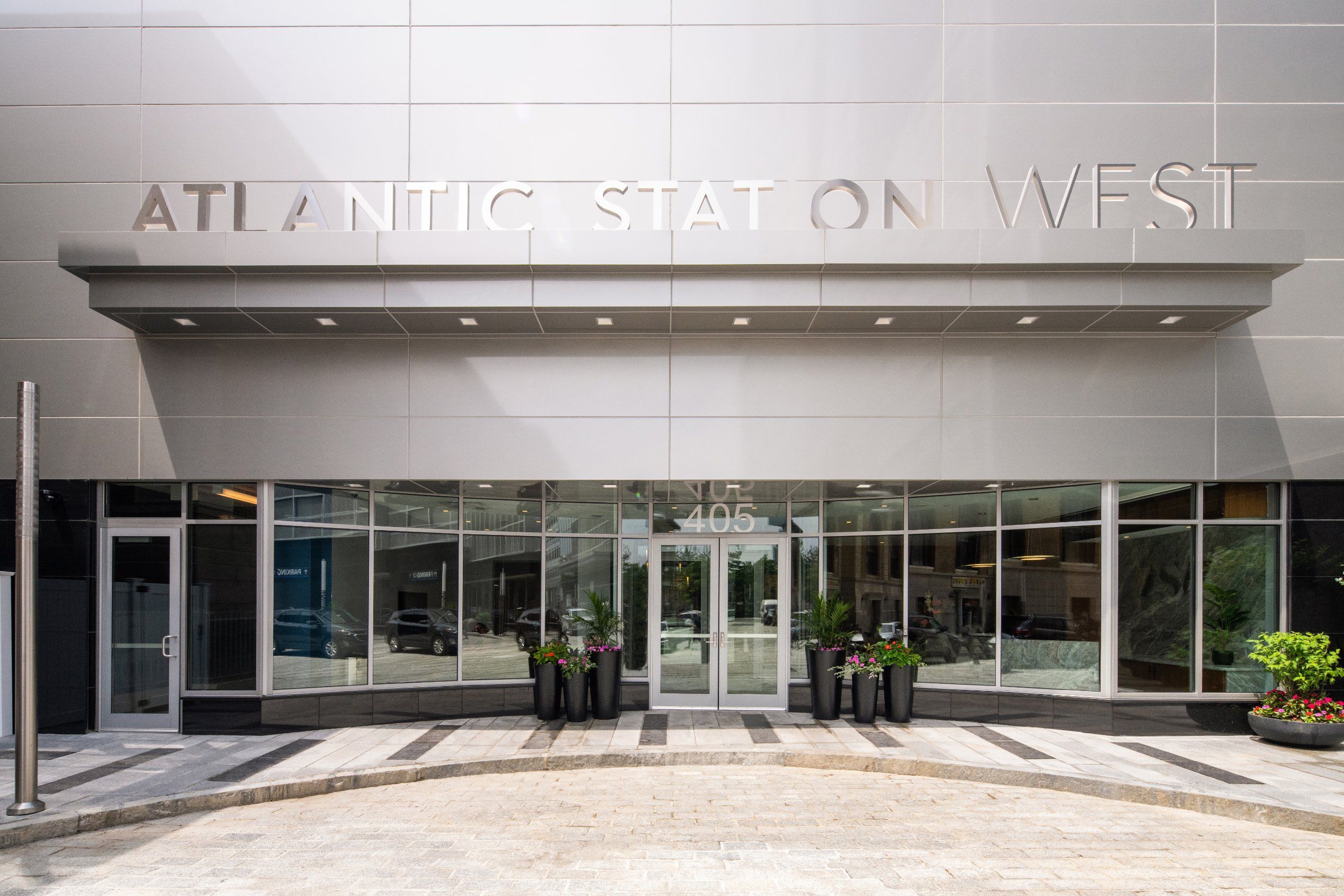 Entrance of Atlantic Station West building with modern design and glass doors.