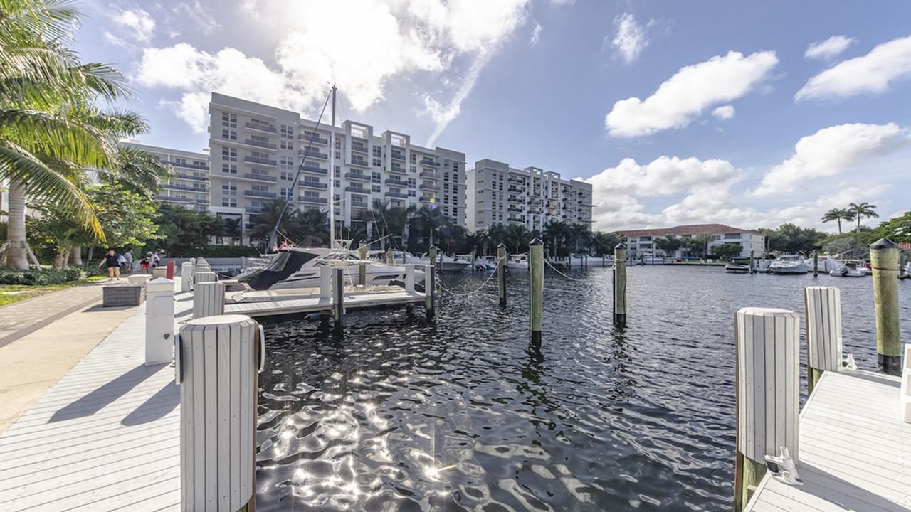 Marina view with docked boats and an apartment building in the background.