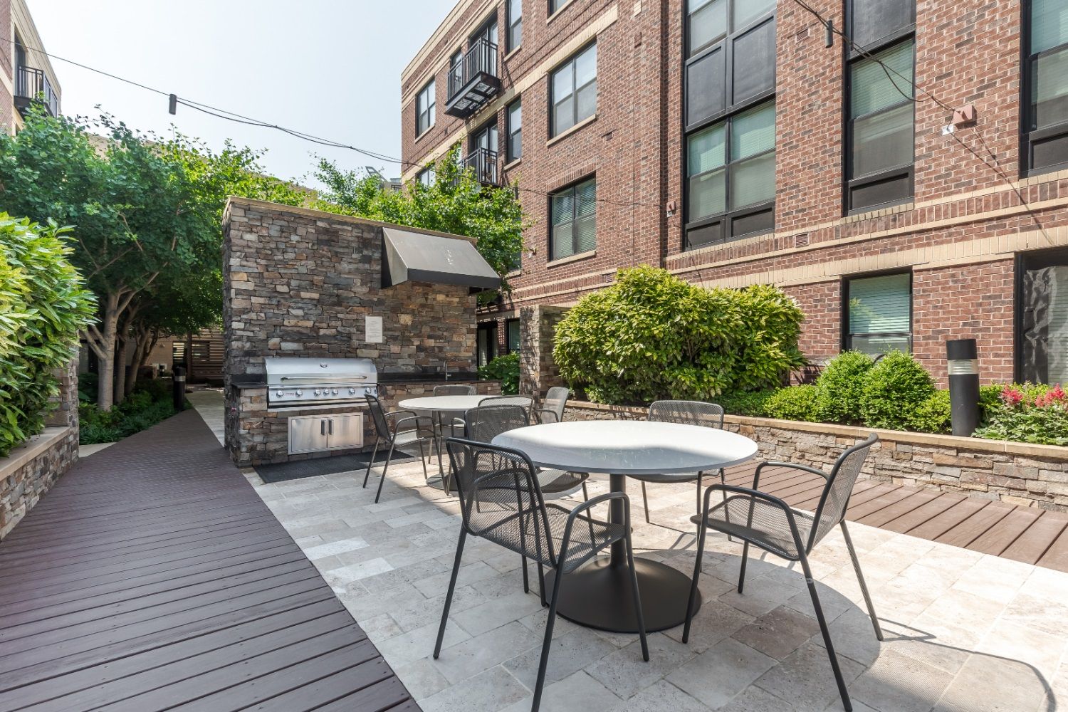 Image showing Outdoor grill station with stainless steel grills and modern seating area.