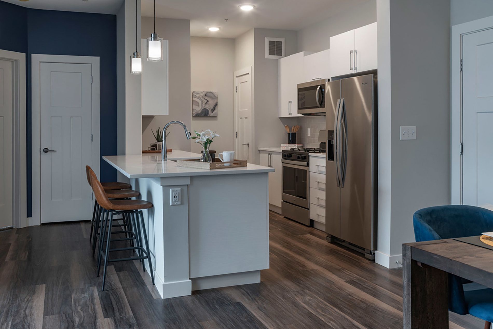 Modern kitchen with stainless steel appliances and a central island, featuring minimal decor.