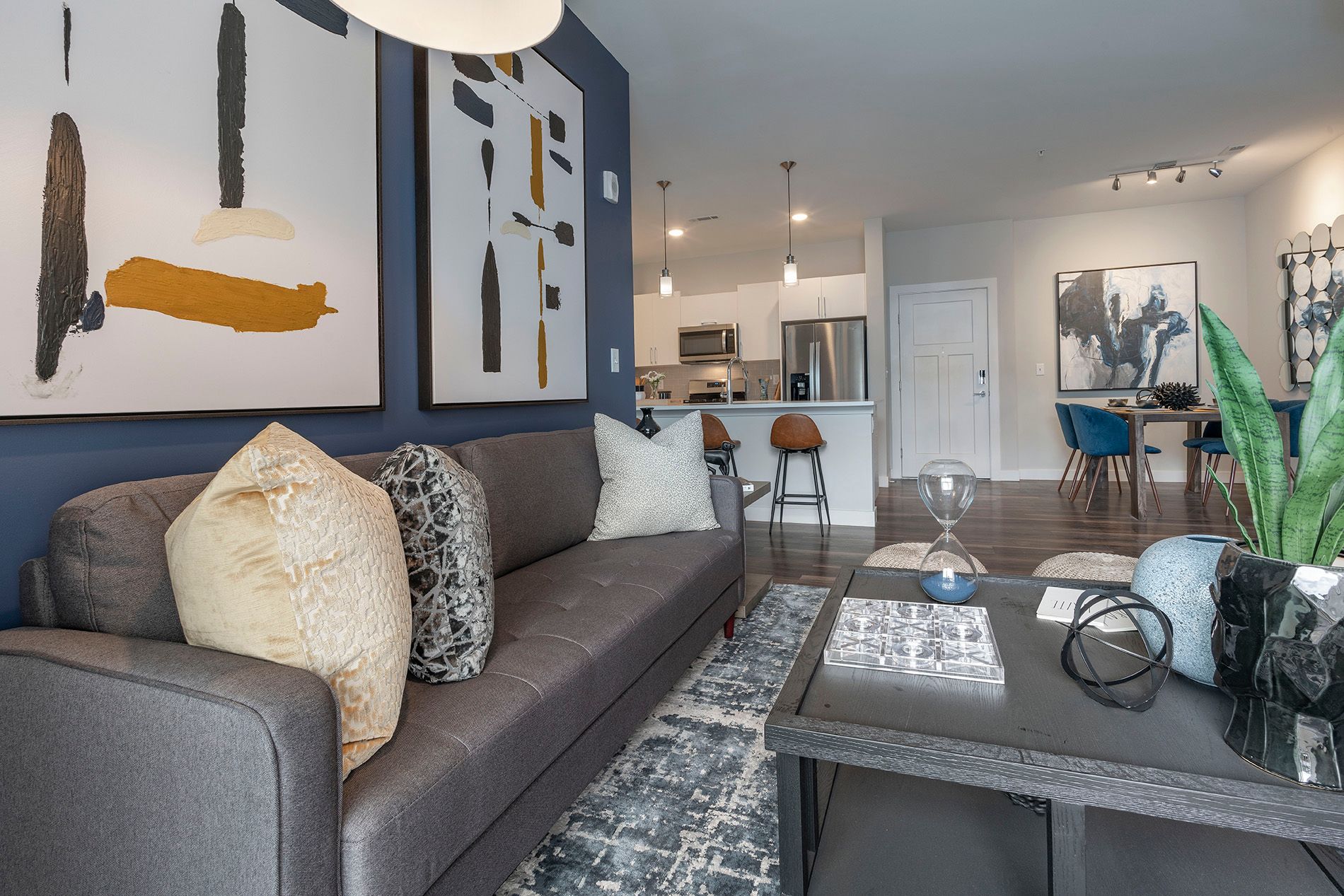 Modern living room with art, a sofa, and dining area in a stylish apartment.